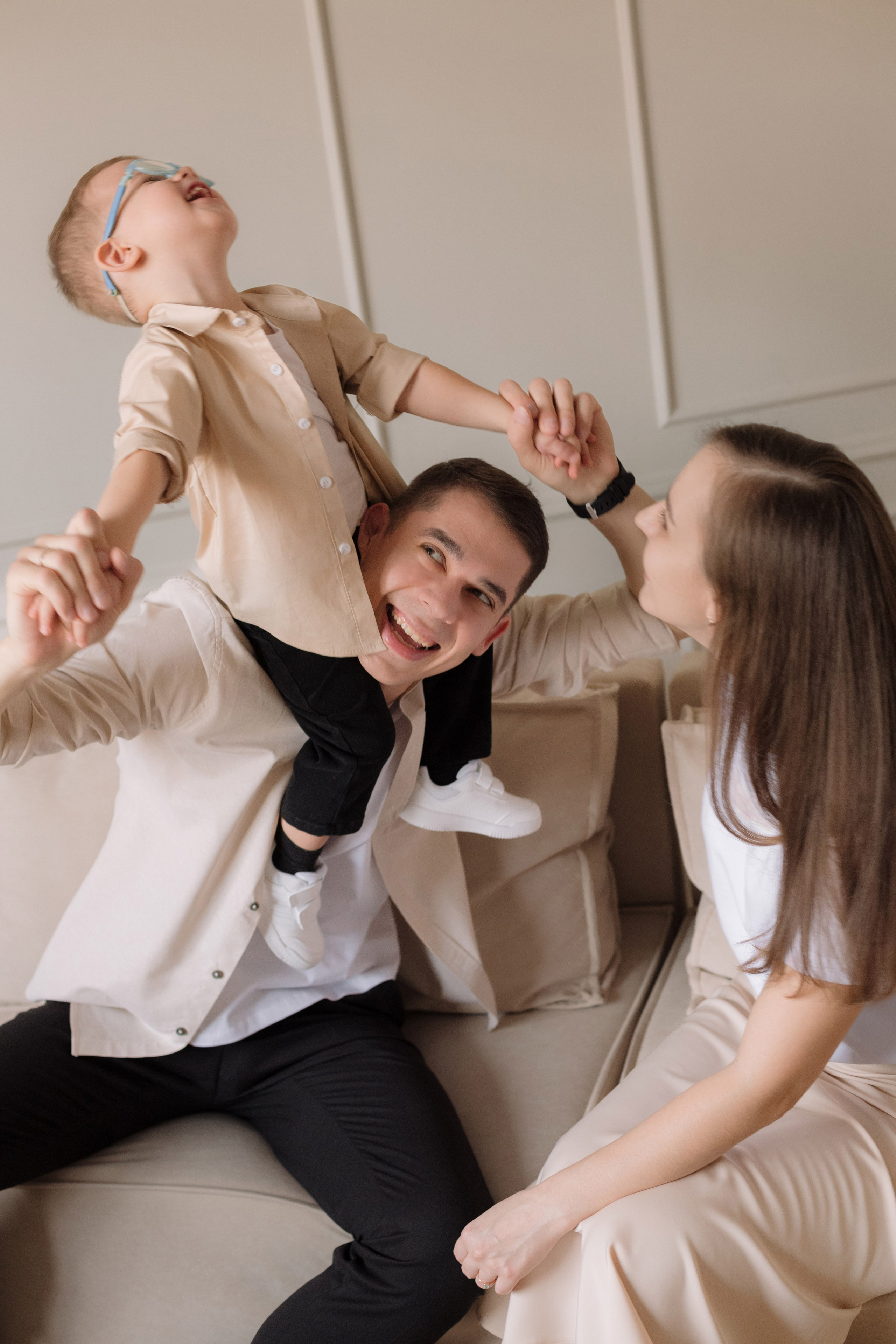 Живая семейная фотосессия в Таганроге в студии — папа поднимает сына, эмоциональный момент съёмки