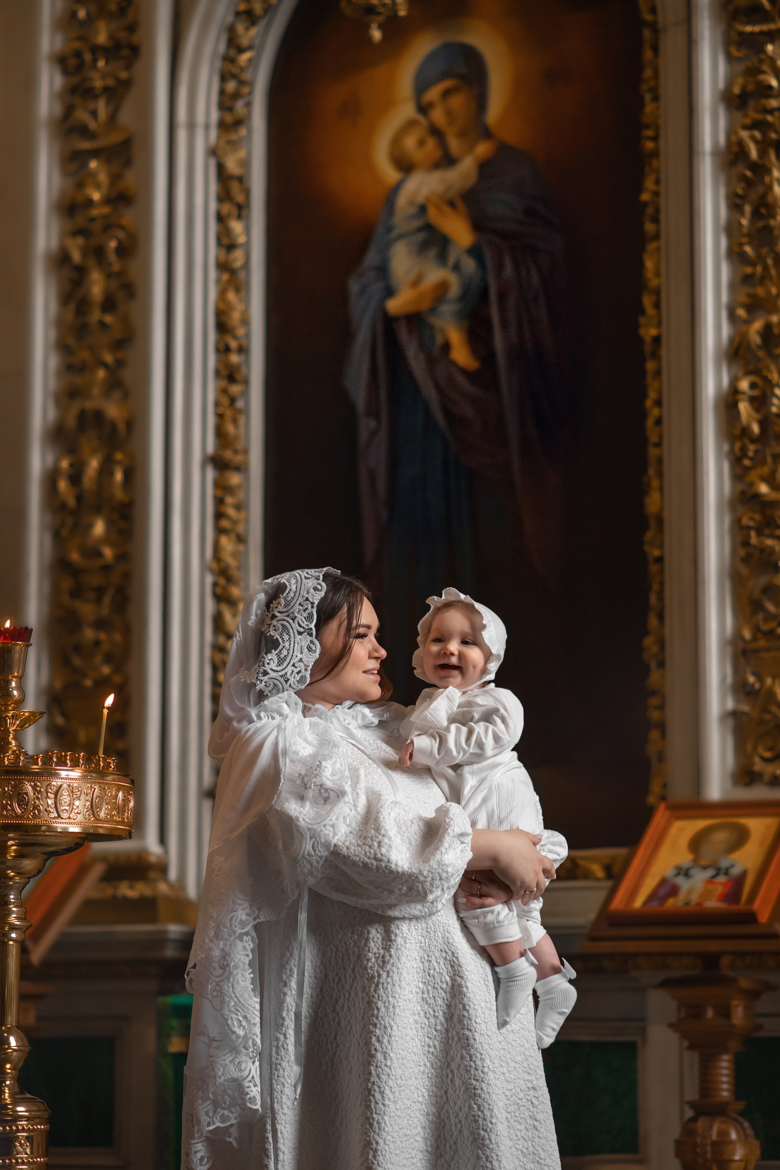 мать и дитя на фоне иконы Богородицы