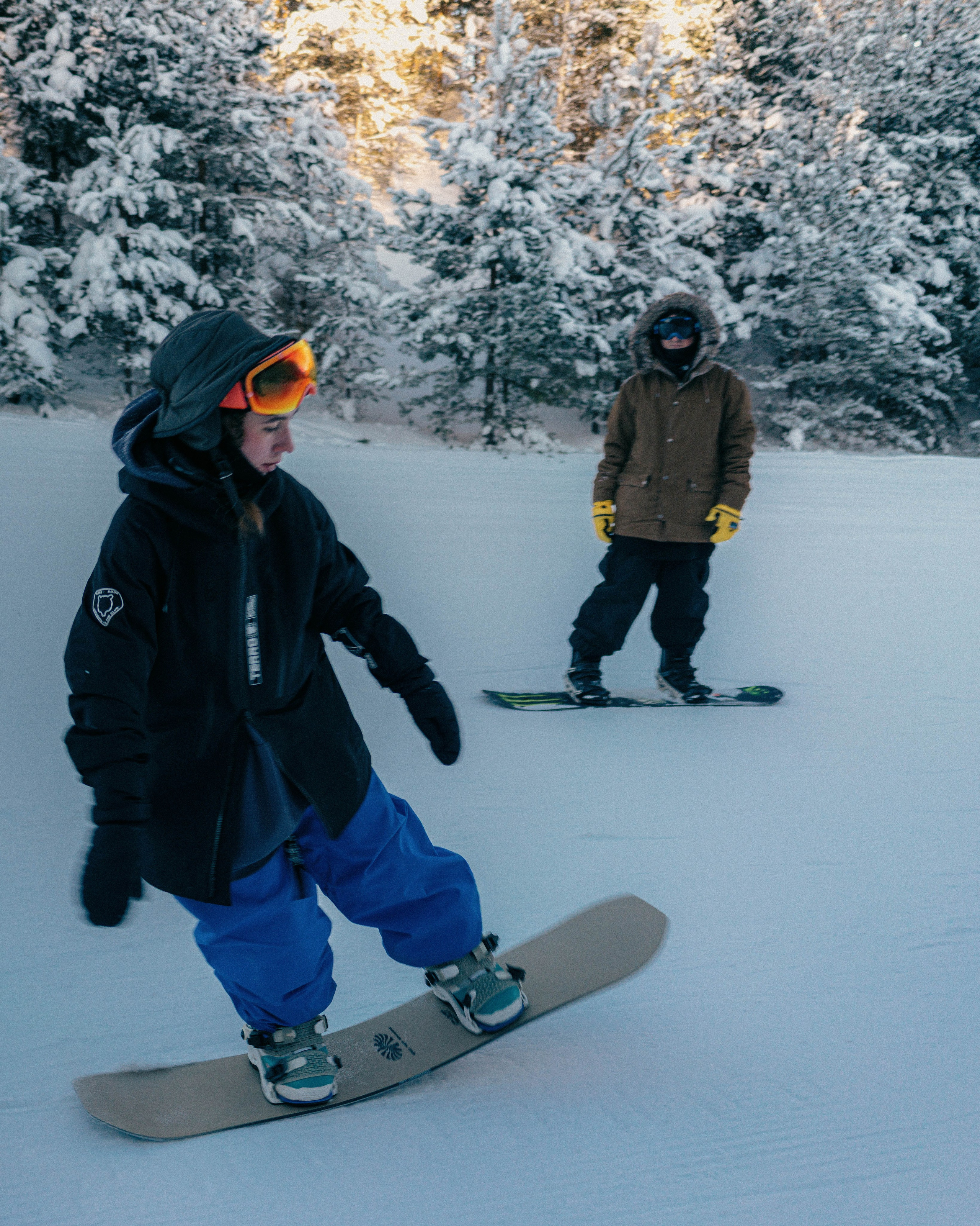 Тренер по сноуборд-фристайлу обучает спортсменку трюку на склоне курорта Игора зимой