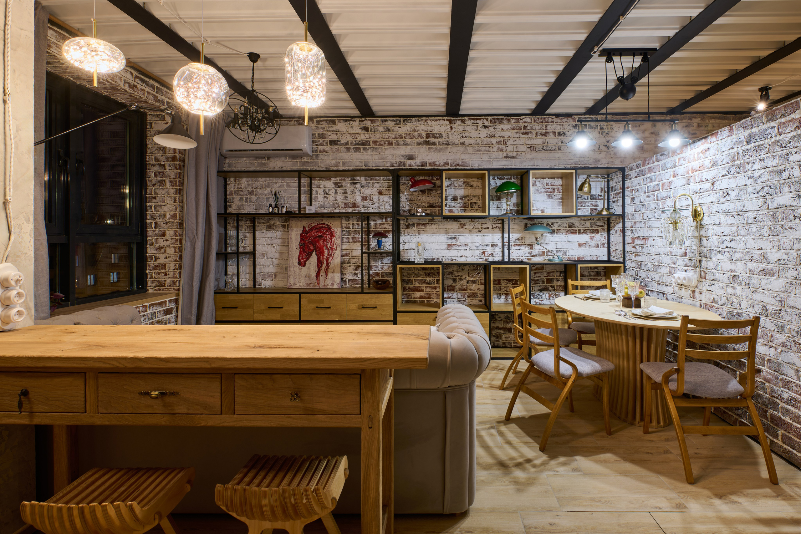 Кухня-столовая: остров, барные стулья, кирпич, потолочные светильники