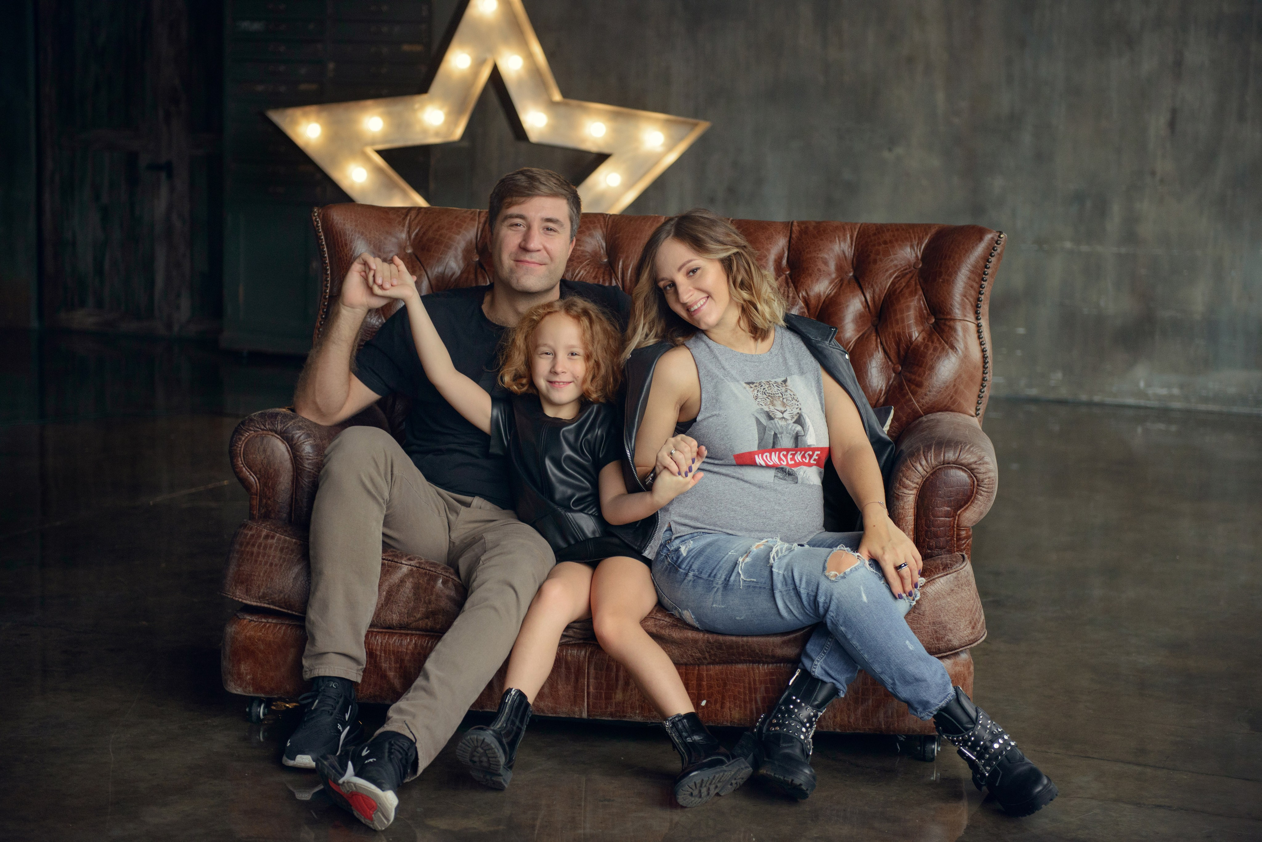 Family photo shoot with a pregnant woman in a loft studio, rock and roll style