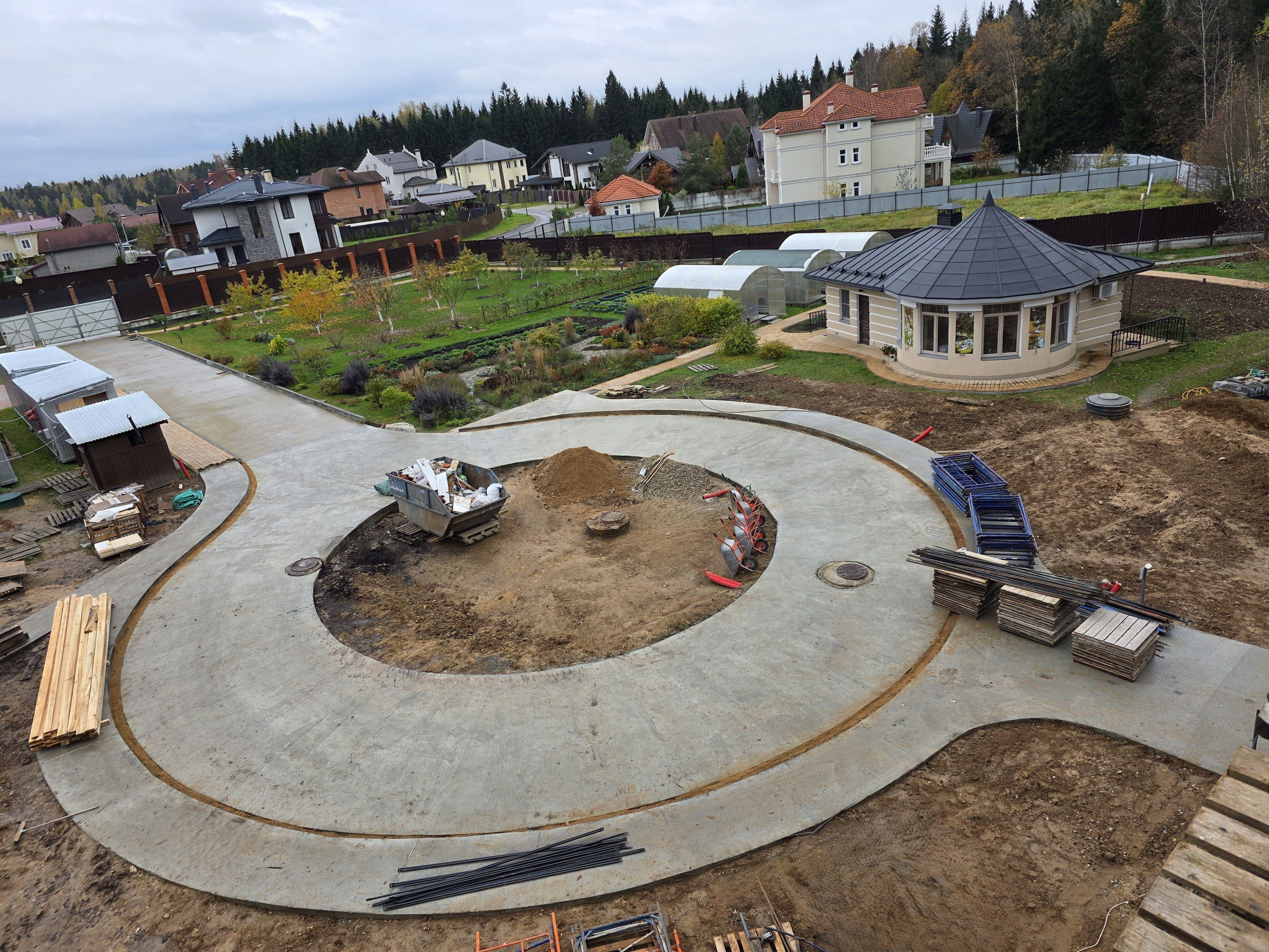 Общий вид участка с домом и бетонными дорожками — строительство в Подмосковье