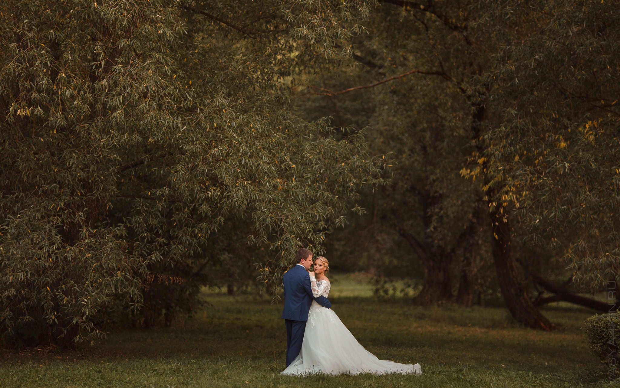Жених держит руку невесты, словно крылья ангела, защищая их любовь от всего зла на этой захватывающей свадебной фотографии