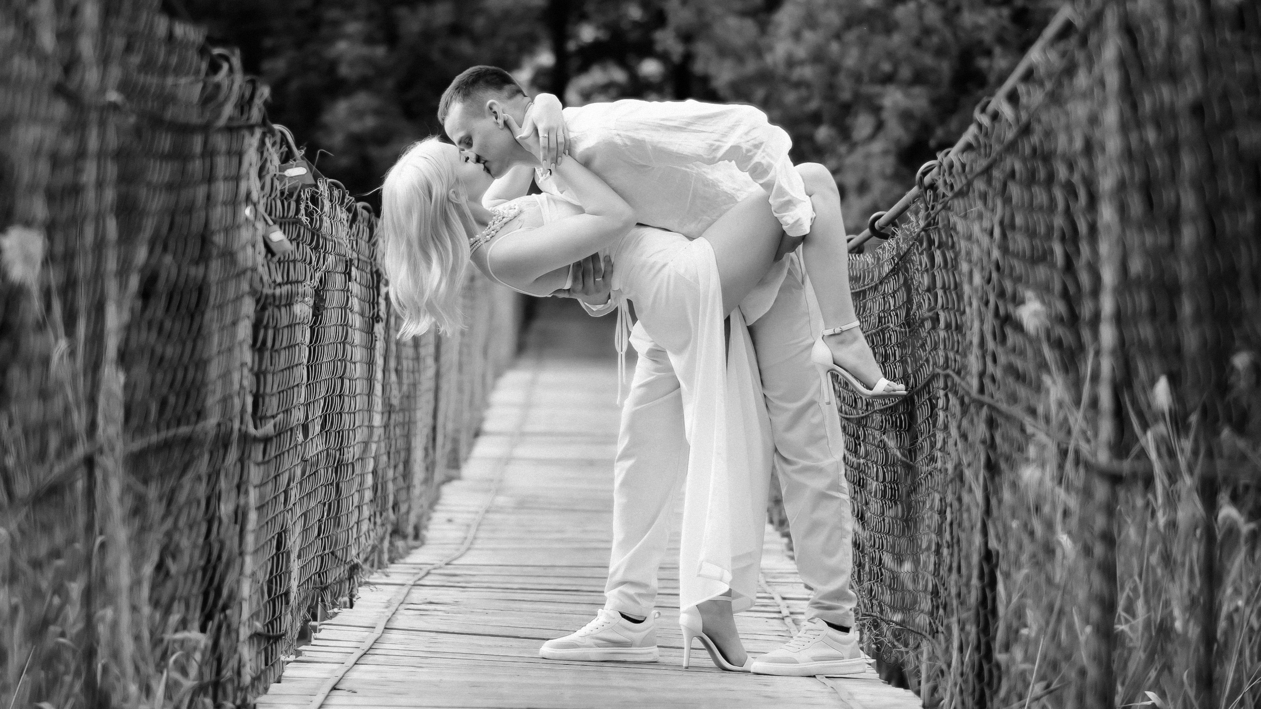 Черно-белая свадебная фотография на подвесном мосту