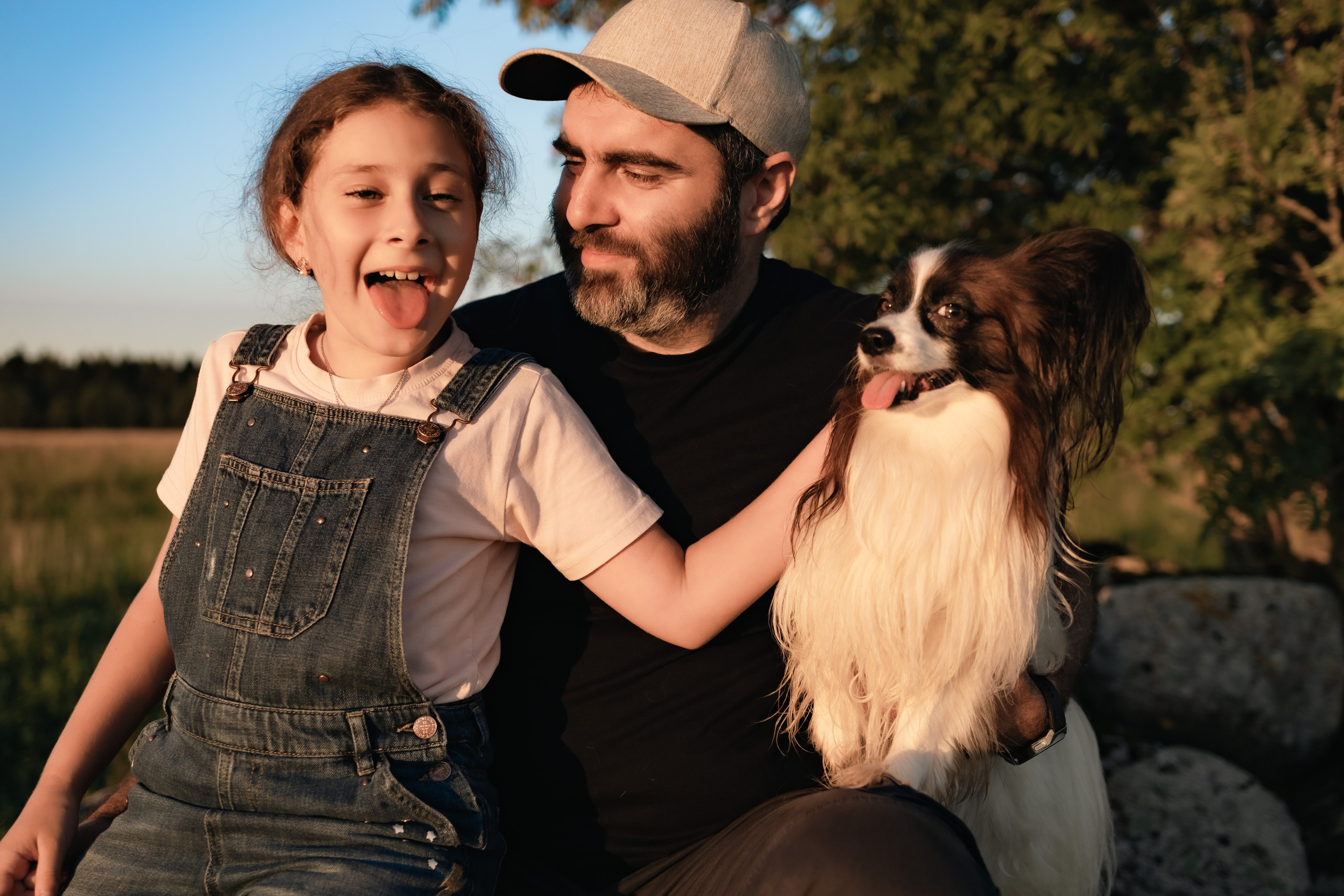 папа дочь и их верный пес сидят под деревом и отдыхают