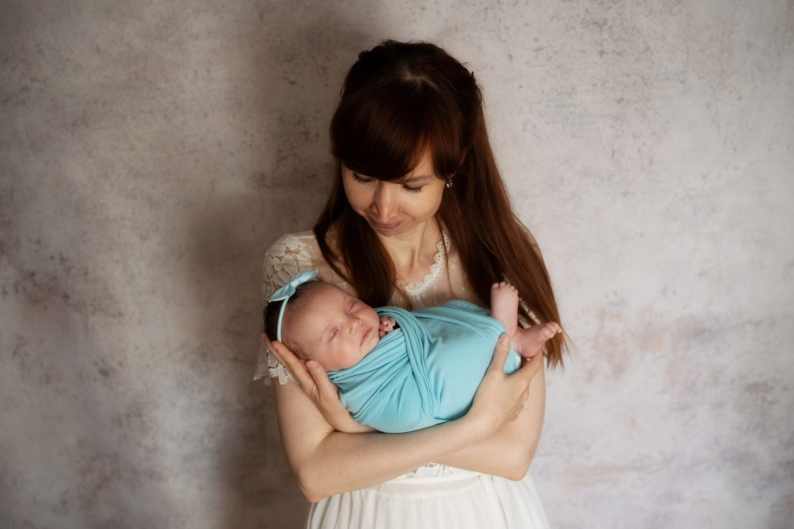 мама нежно держит новорожденного малыша