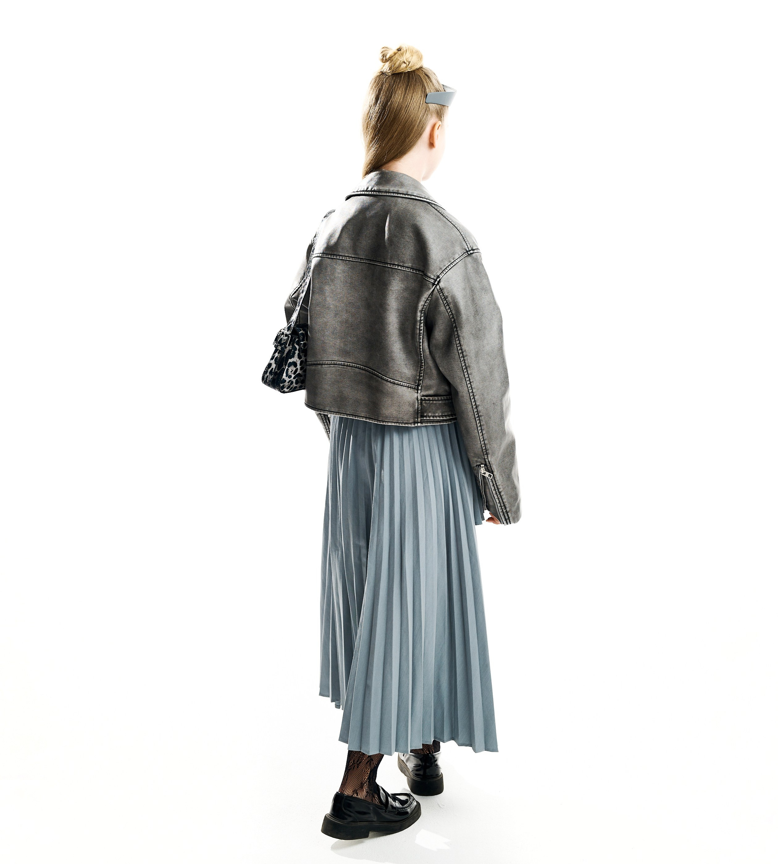 Девушка модель в серой кожаной куртке косухе и синей юбке