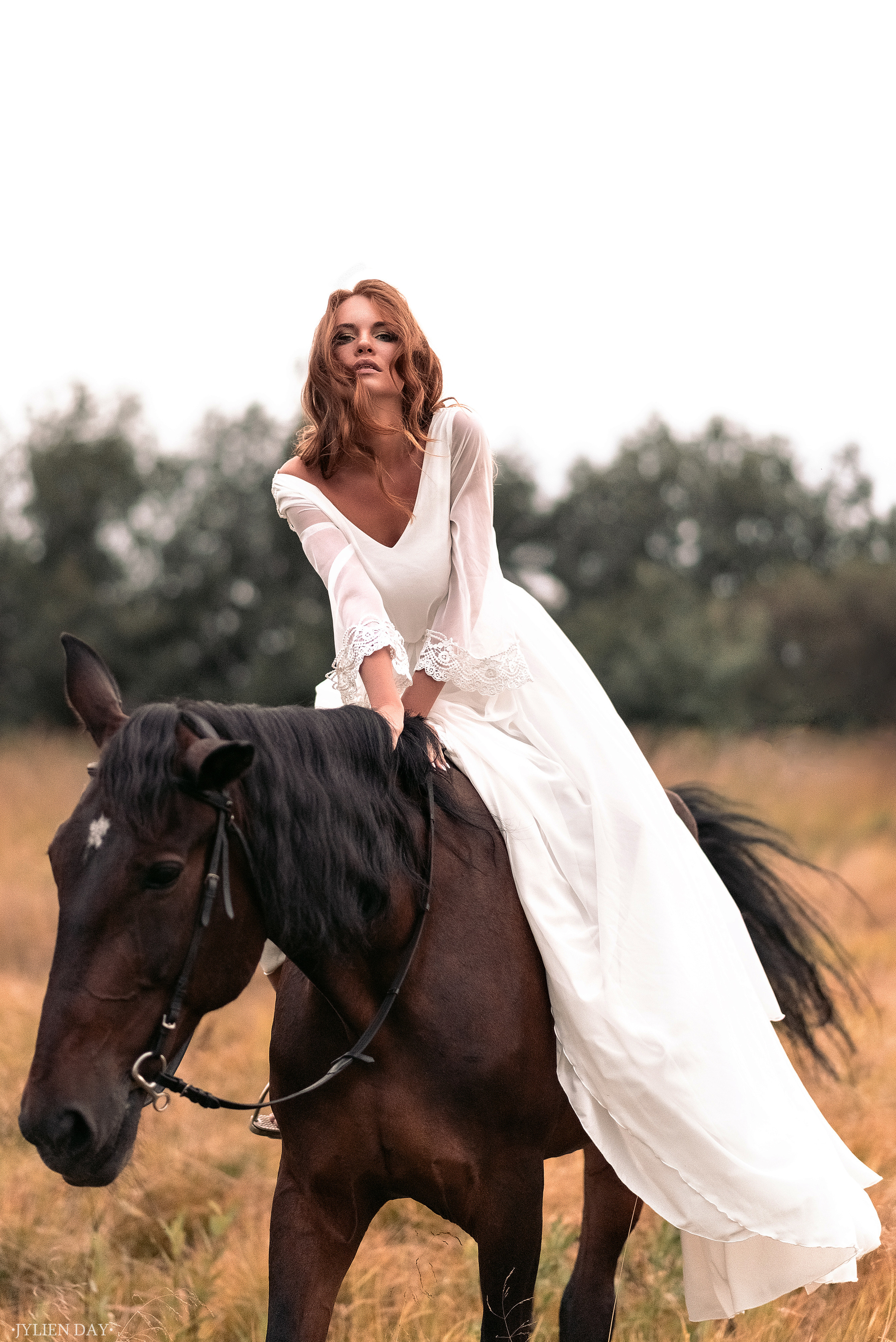 Рыжеволосая невеста в свадебном платье верхом на лошади