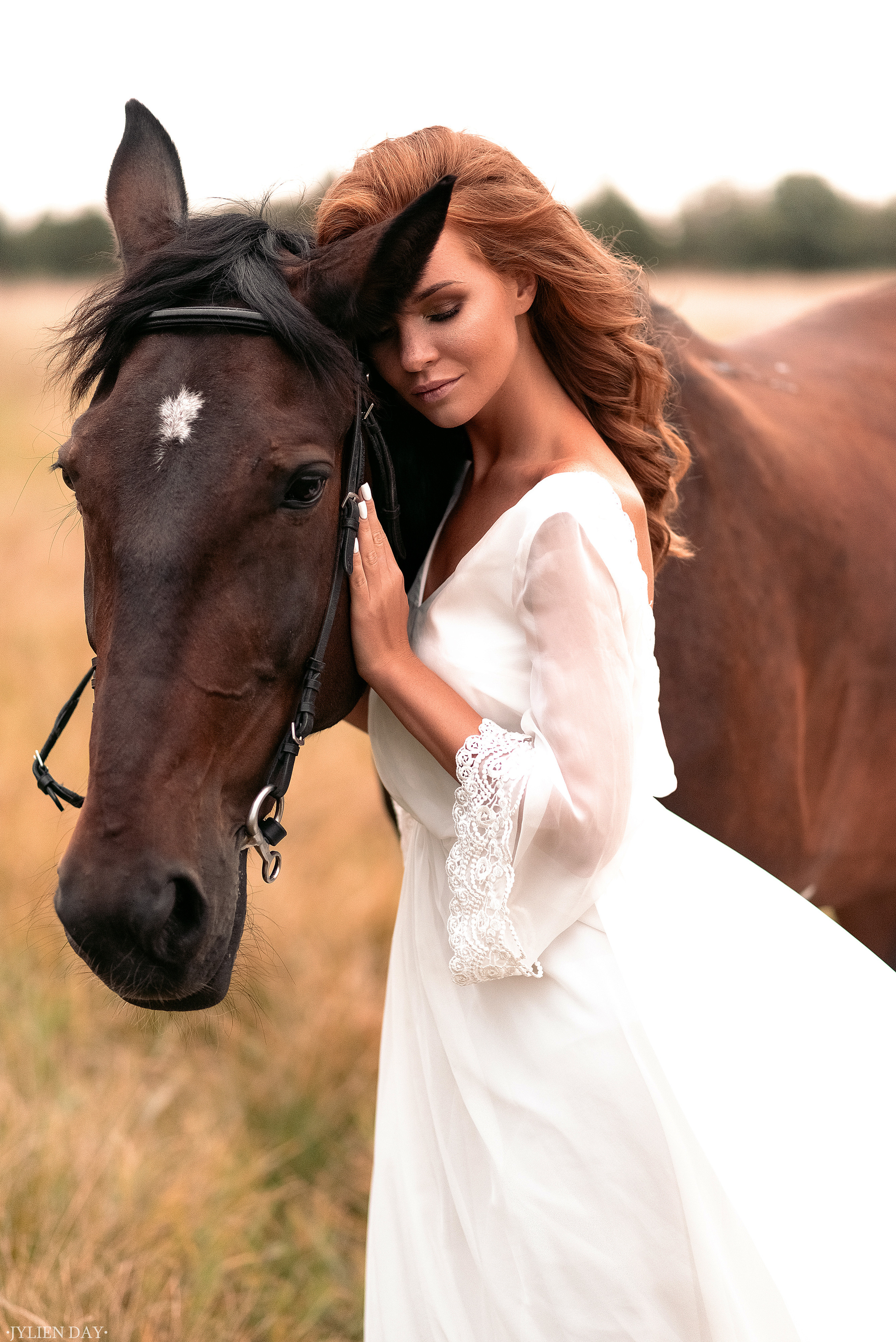 Рыжеволосая девушка в поле с лошадью