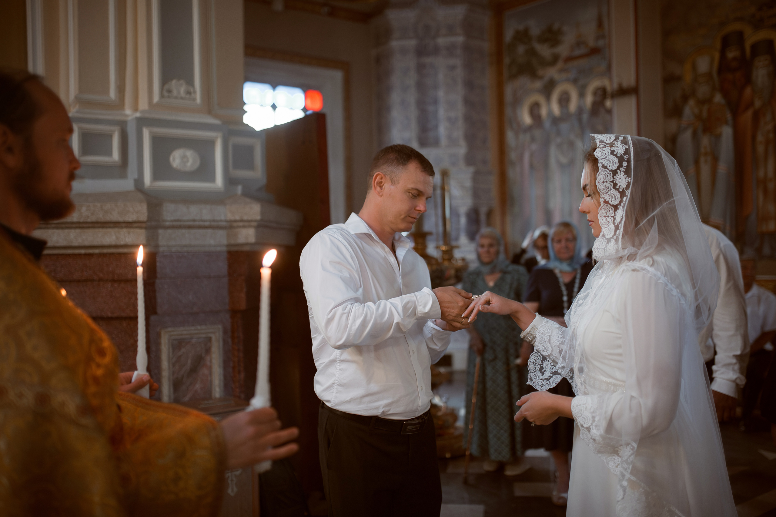 муж и жена обмениваются кольцами на венчании в Ташкенте