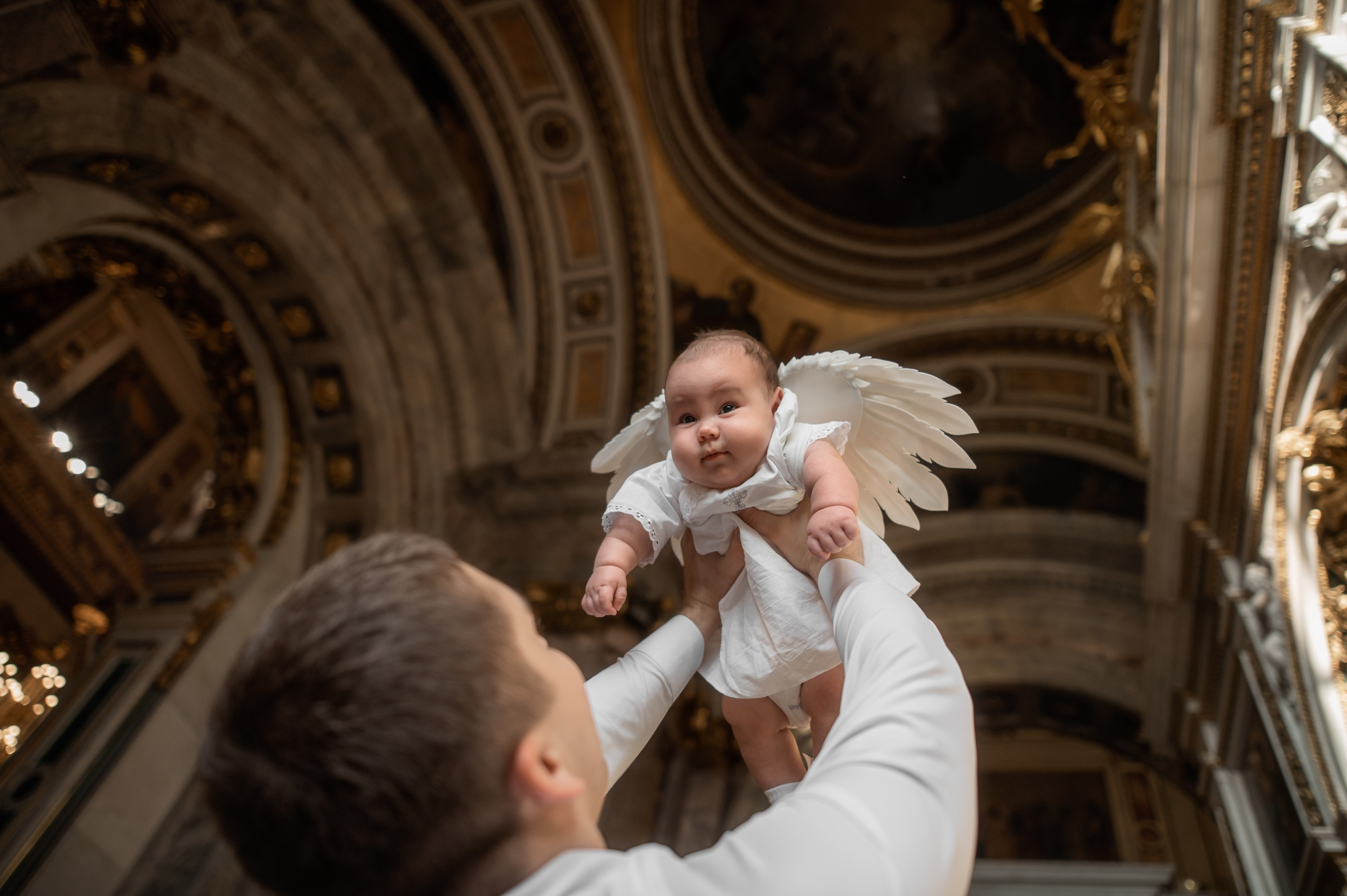 папа поднимает на руках малыша под купол собора