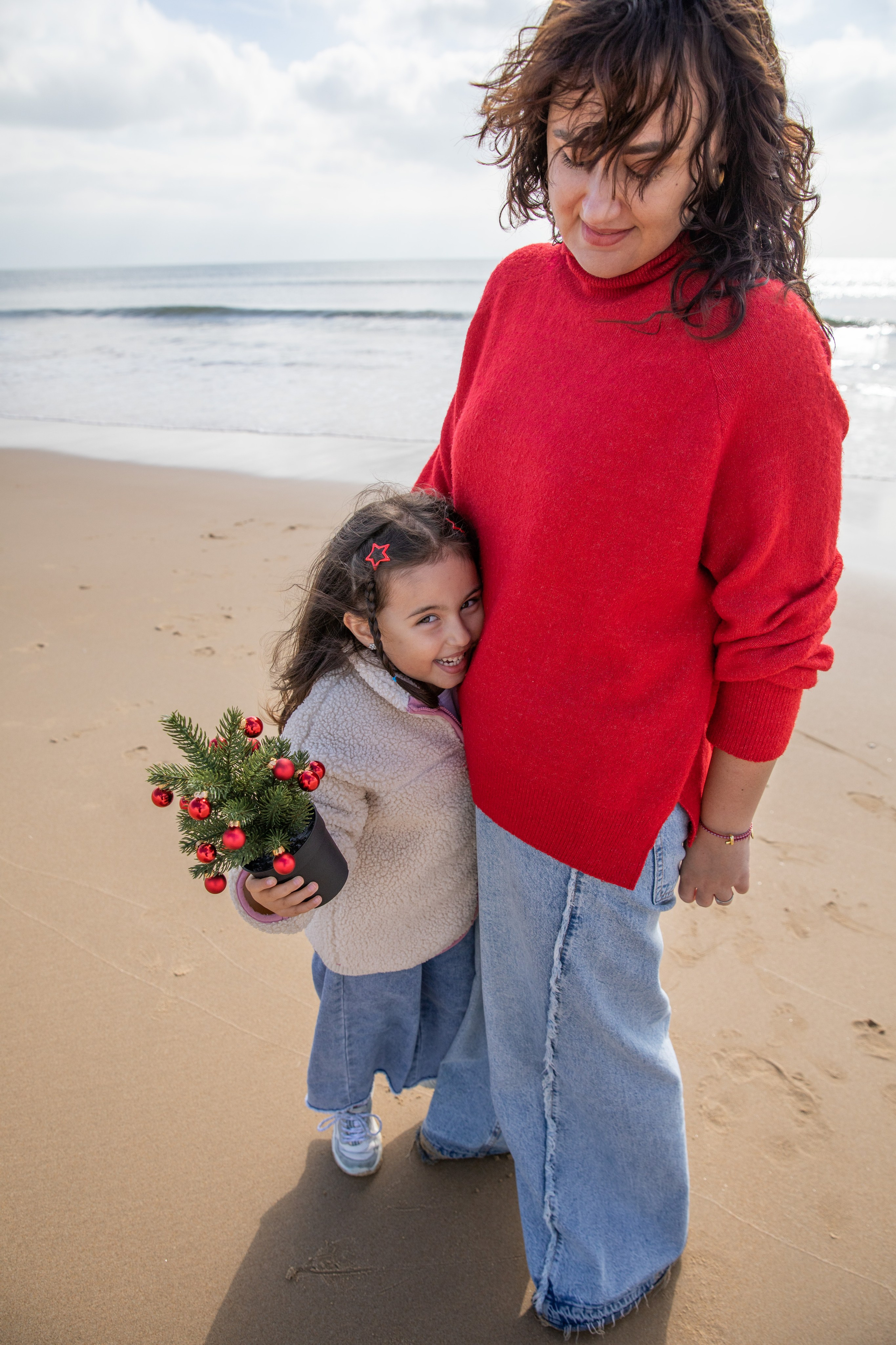 Mum and daughter walking hand in hand, enjoying a peaceful stroll along the beach
