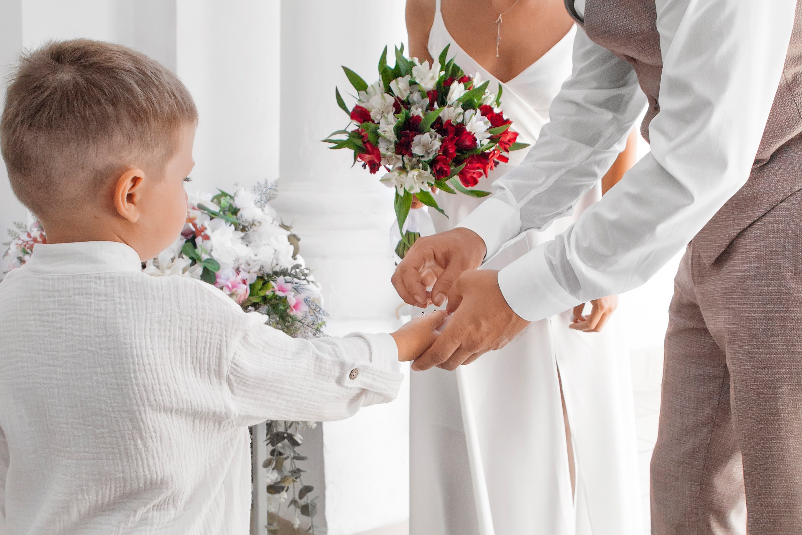 Ребенок подаёт кольца молодым для проведения обряда обмена кольцами - фотосъёмка свадьбы Ульяновск
