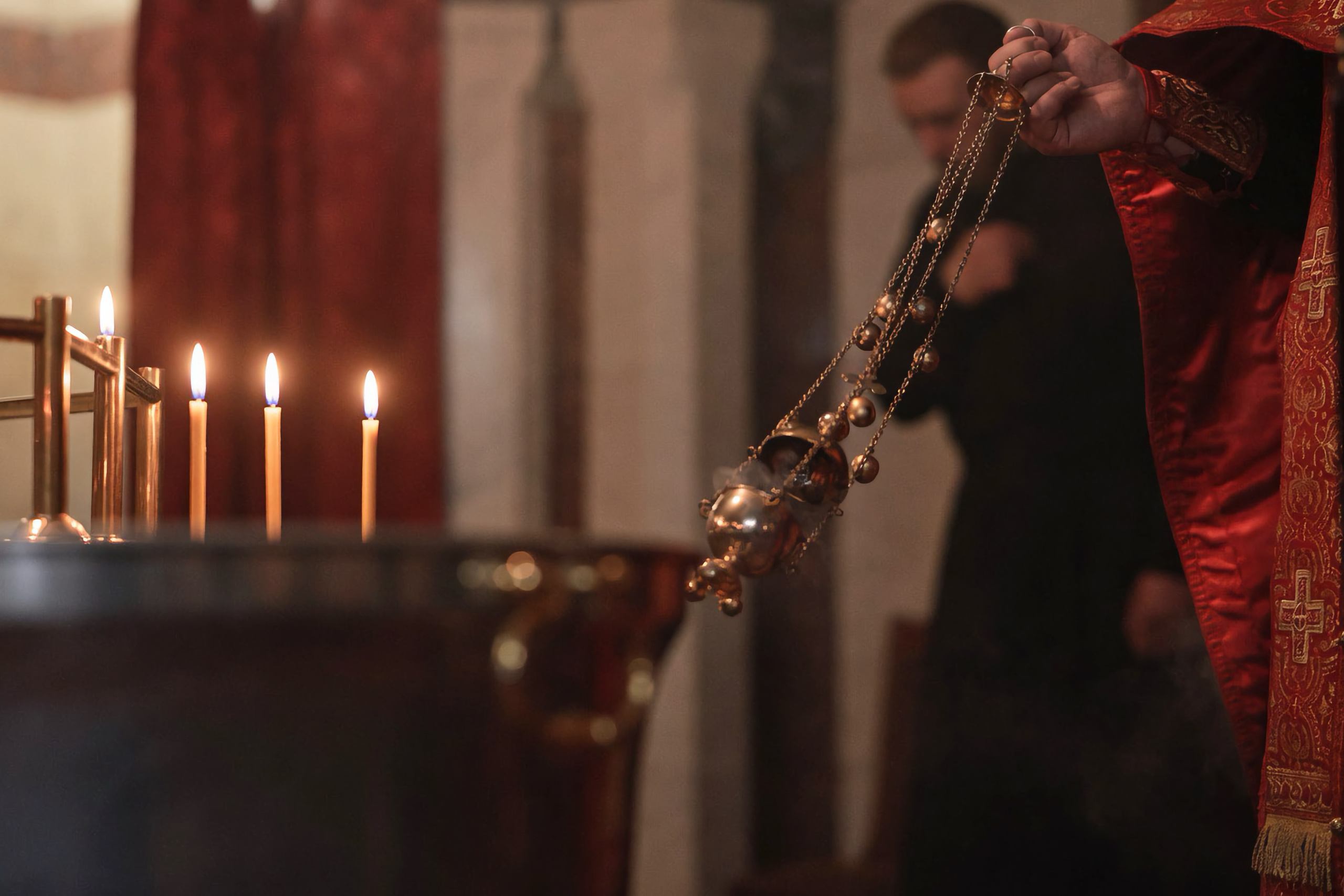 Таинство Крещения в Храме на Крови, Екатеринбург. Золотистые блики на воде купели и мягкий свет церковного интерьера. Фотограф Илья Антропов