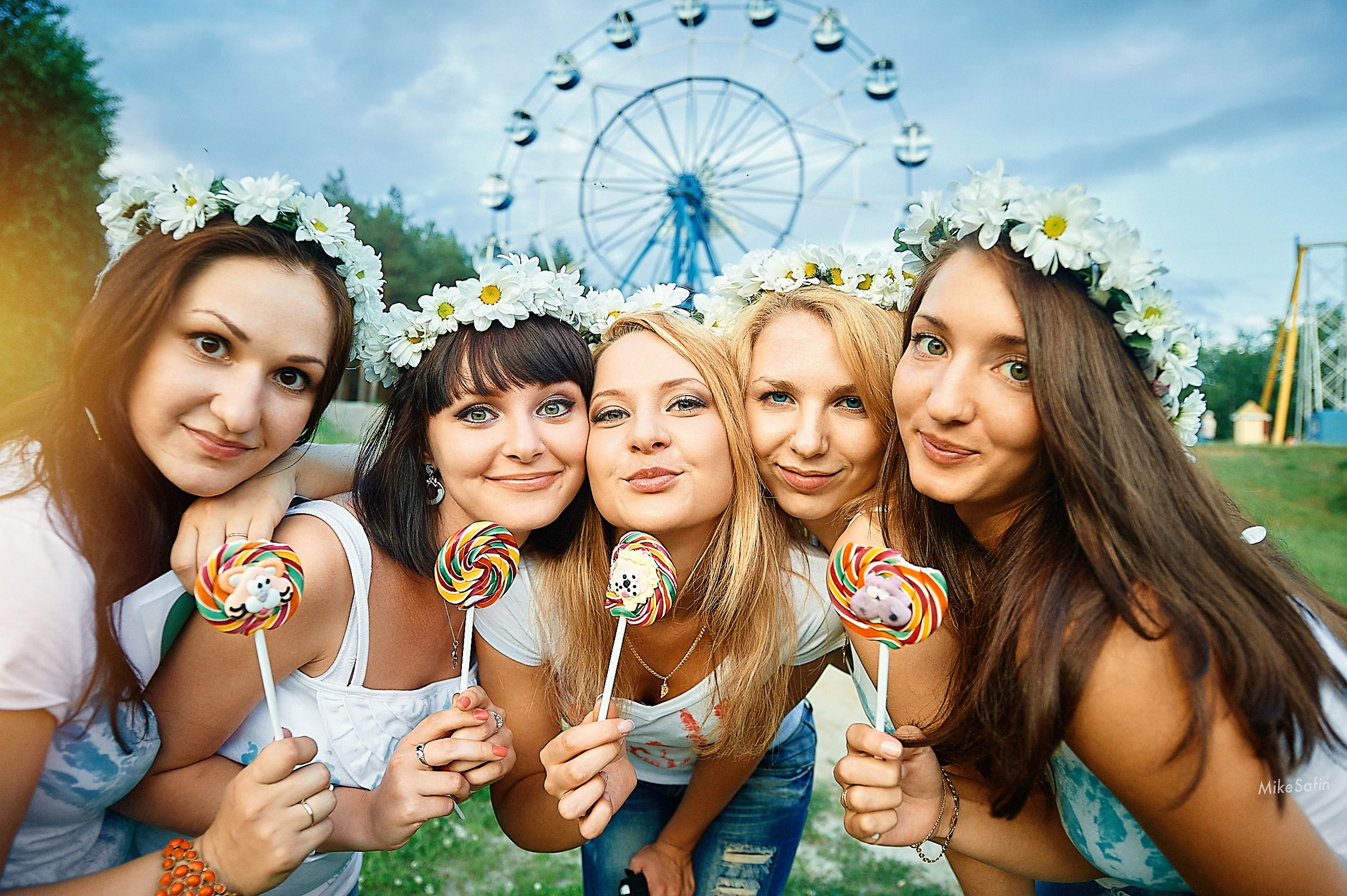 Подружки невесты с конфетами на фоне аттракционов