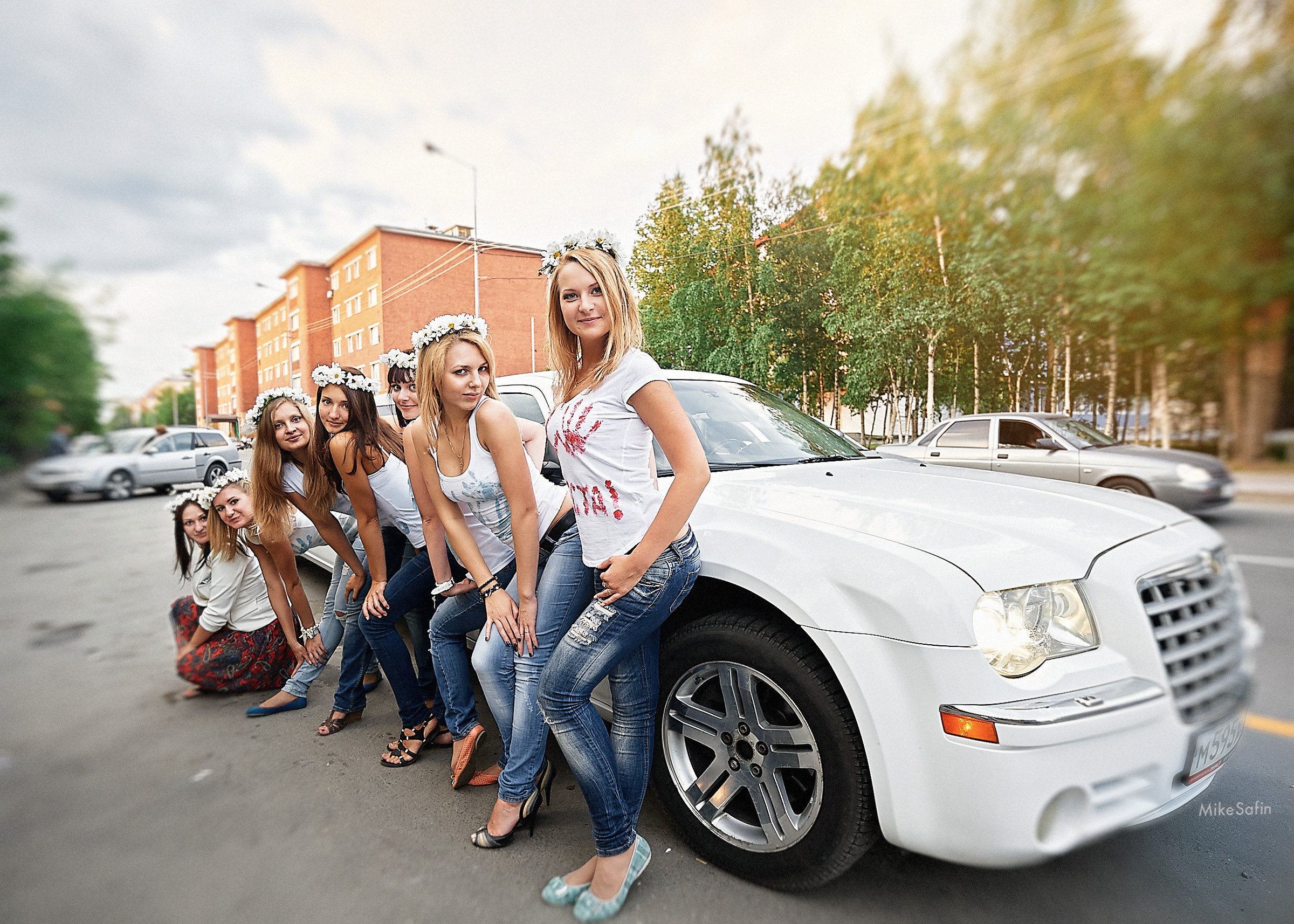 Девушки с венками на голове у лимузина на празднике