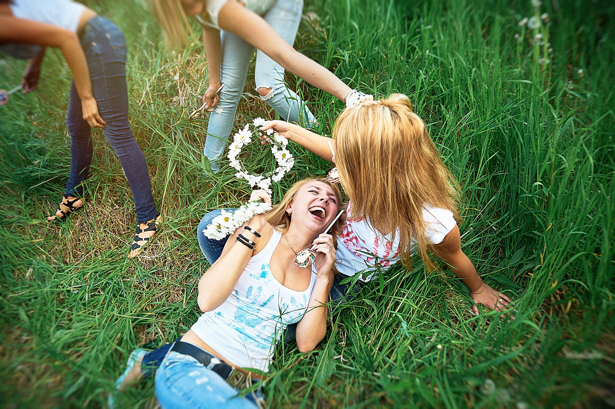 Девушки валяются на траве, шутят и дурачатся