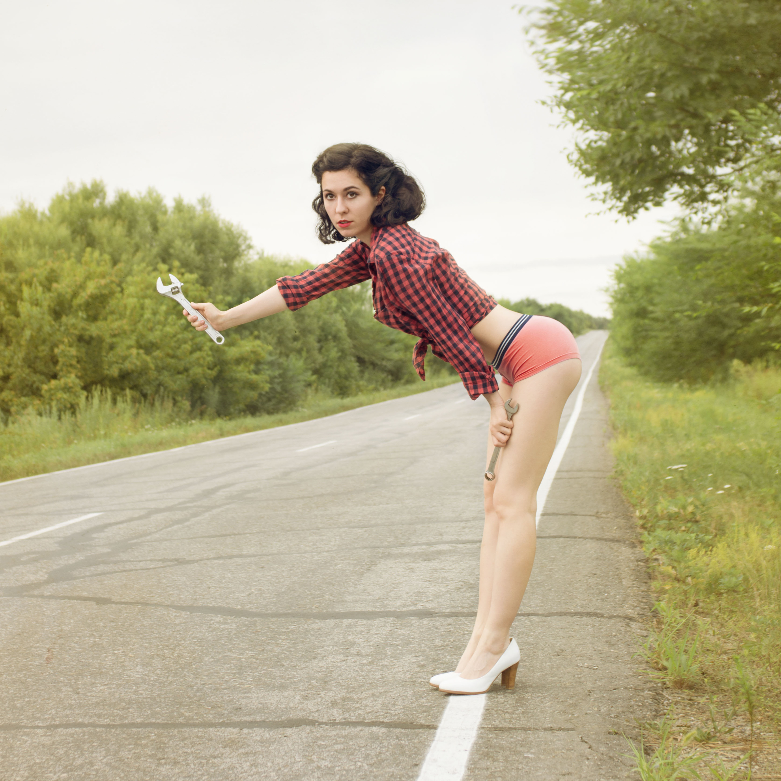 Девушка в стиле пинап, стоит на дороге