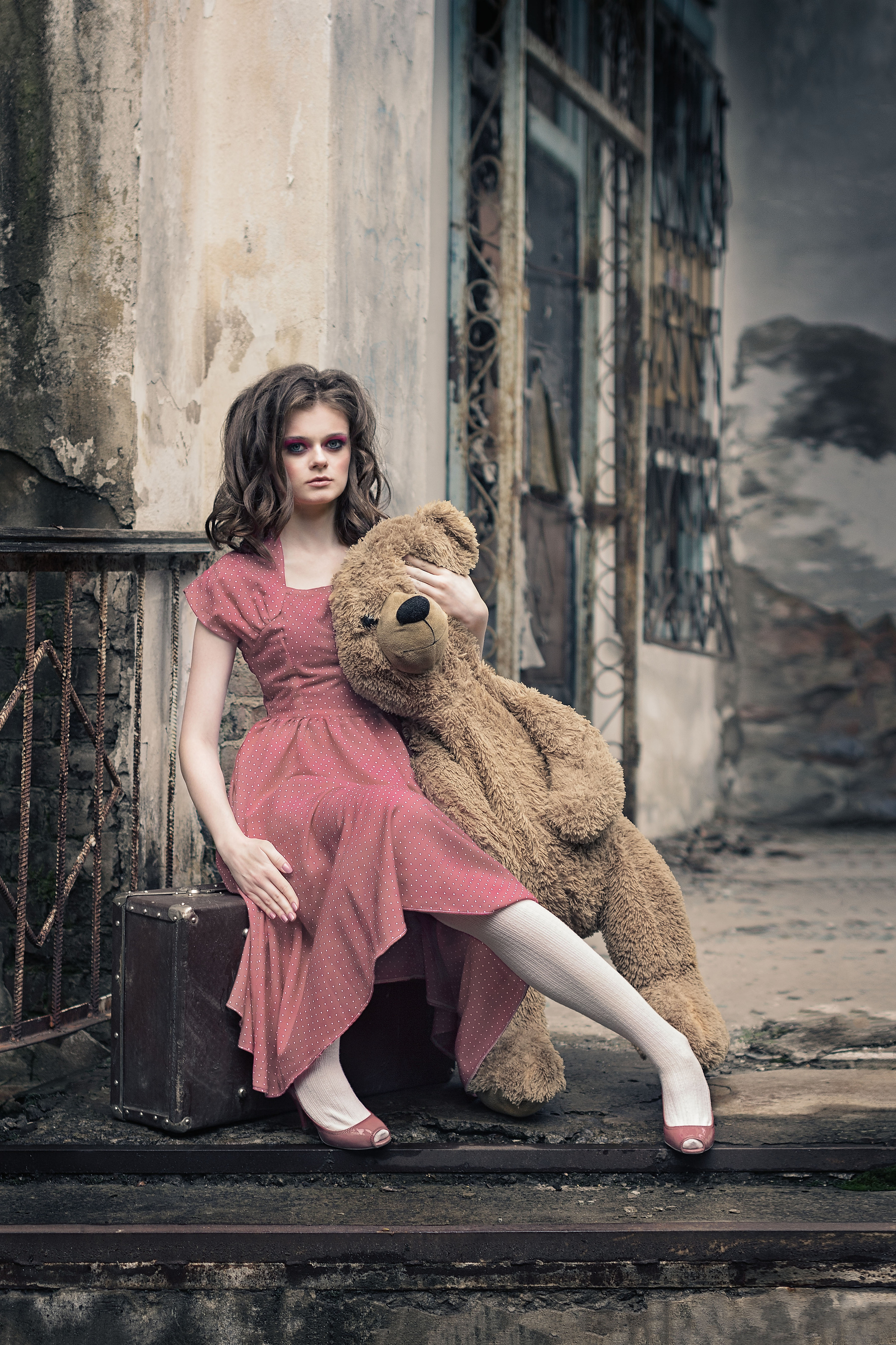 Девушка в красном платье с большим плюшевым медведем