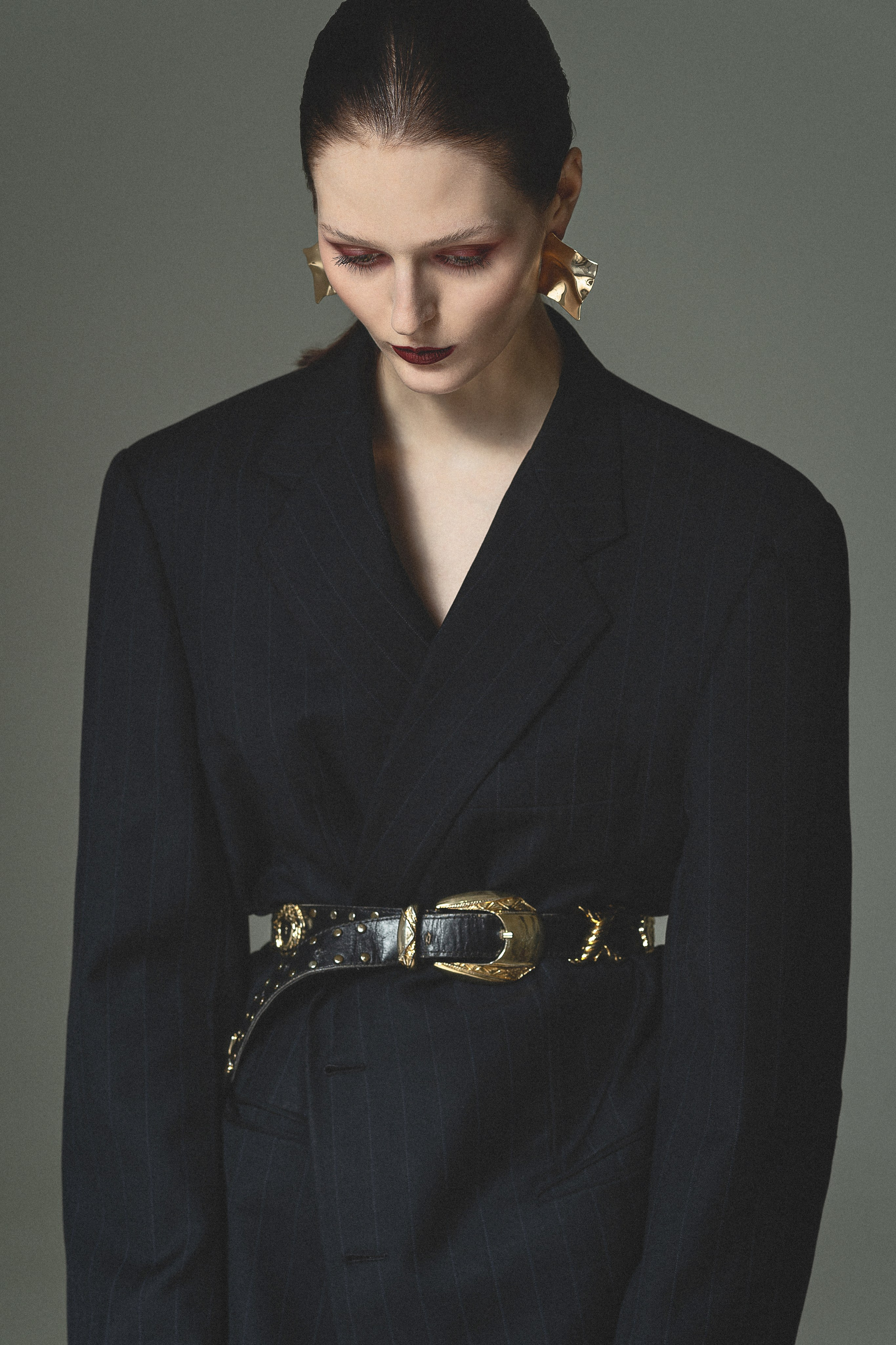Портрет модели в объёмном чёрном жакете с акцентным ремнём в fashion editorial Noir