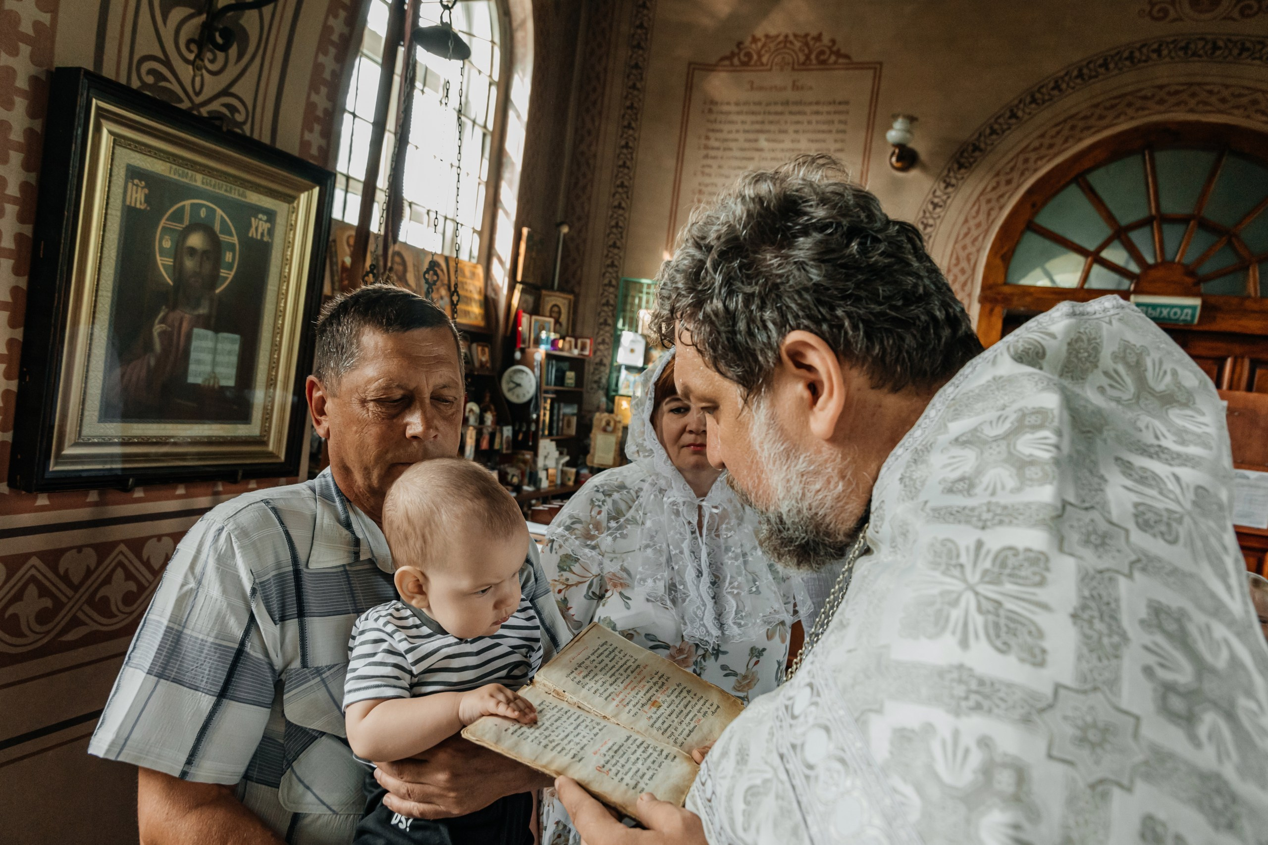 Ребёнок на руках у родителей в храме