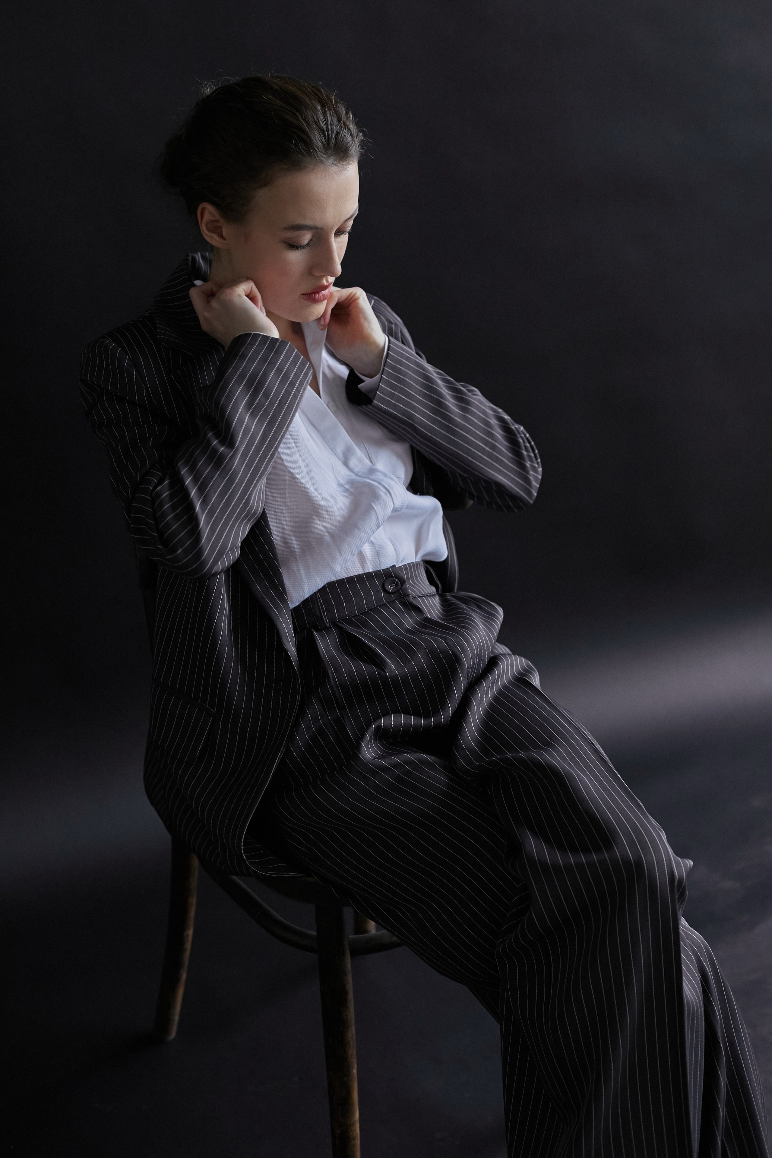 Фотограф в Москве. Студия. Студийный портрет. Девушка в пиджаке. Девушка на стуле на черном фоне. Красивая девушка в мужском костюме. Женский портрет.