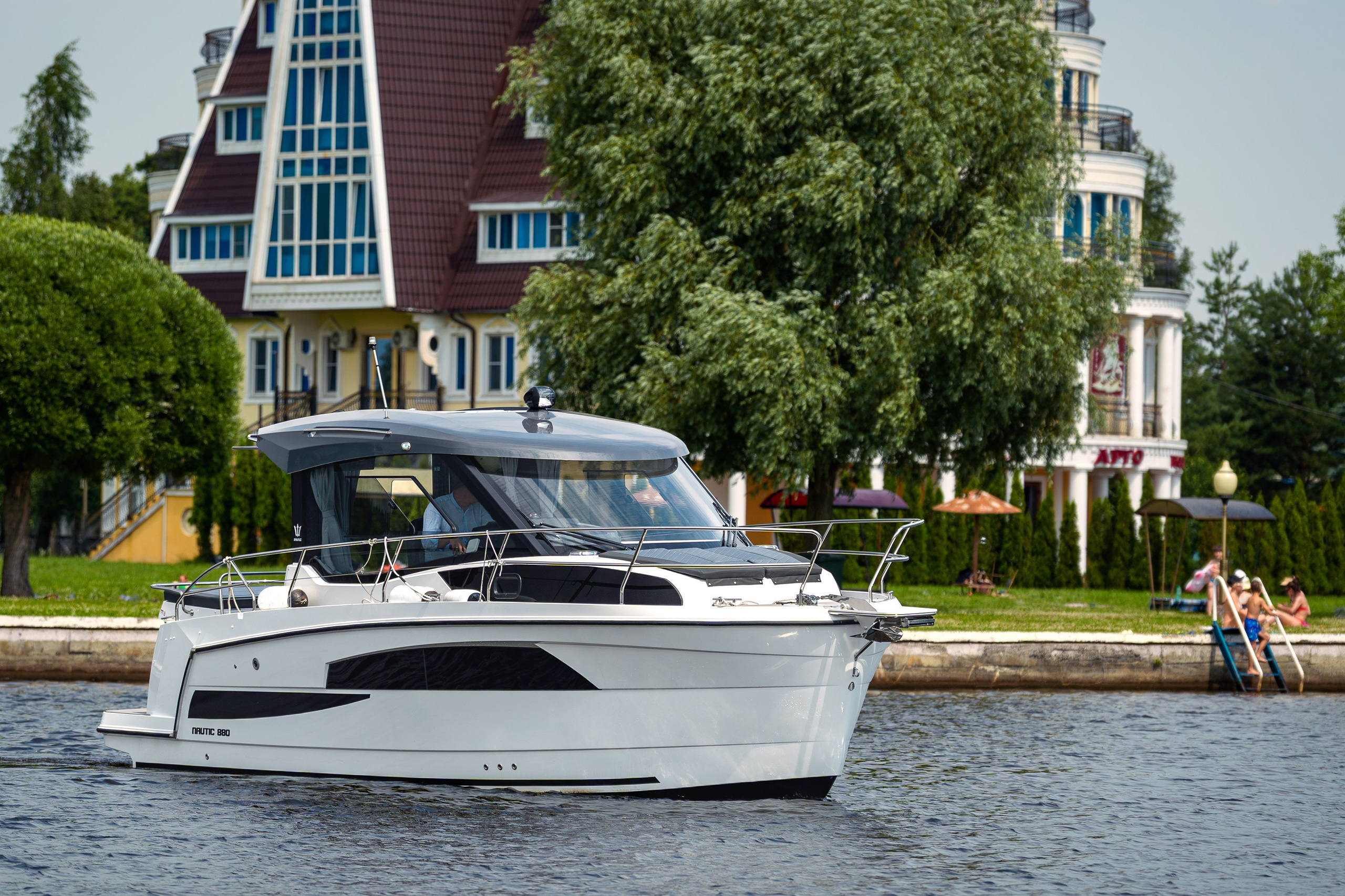 Фотосъёмка катера Nautic 880 на воде, боковой вид на фоне береговой локации