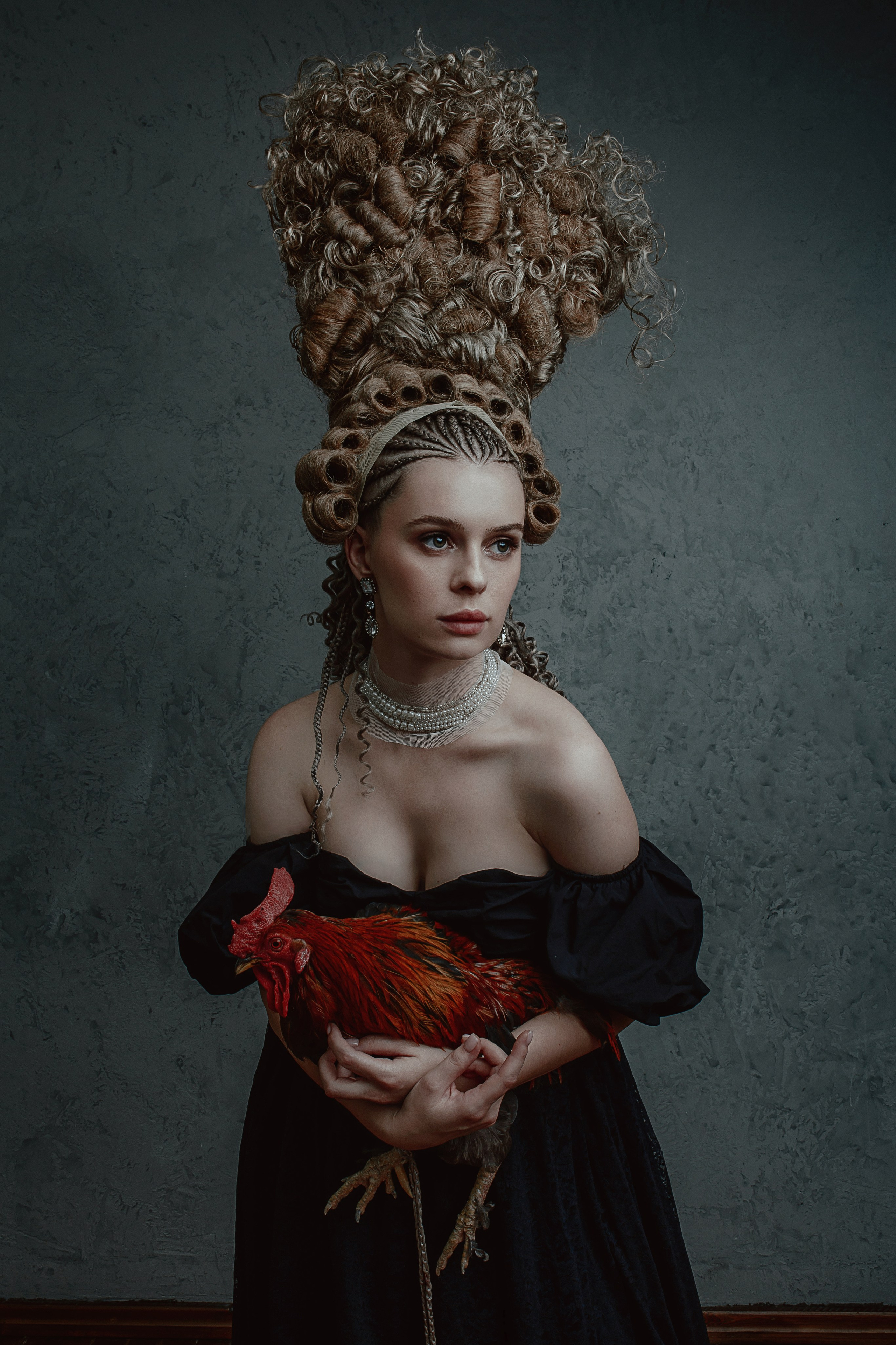 Девушка в средневековом образе держит петуха.