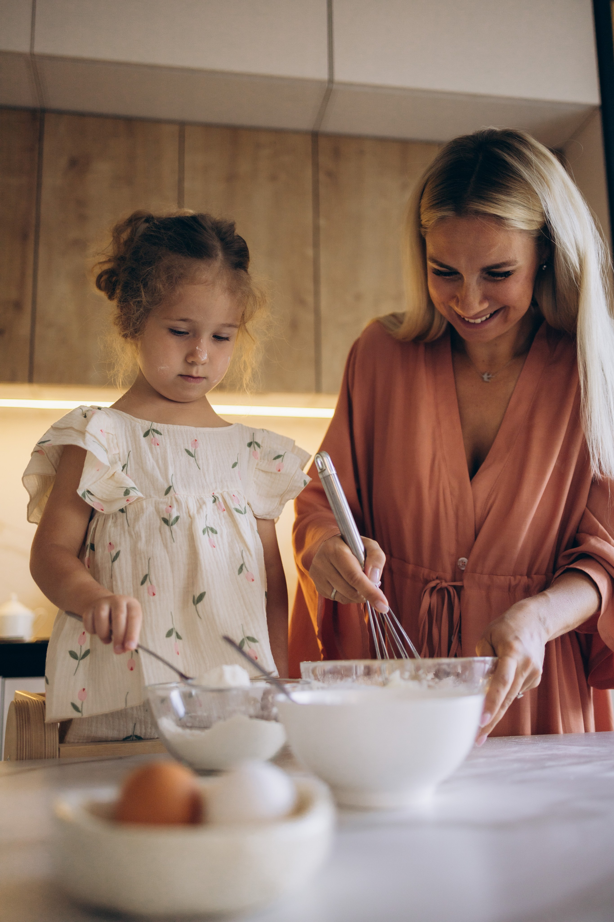 Мама и дочка вместе смешивают ингредиенты, мука растирается по рукам
