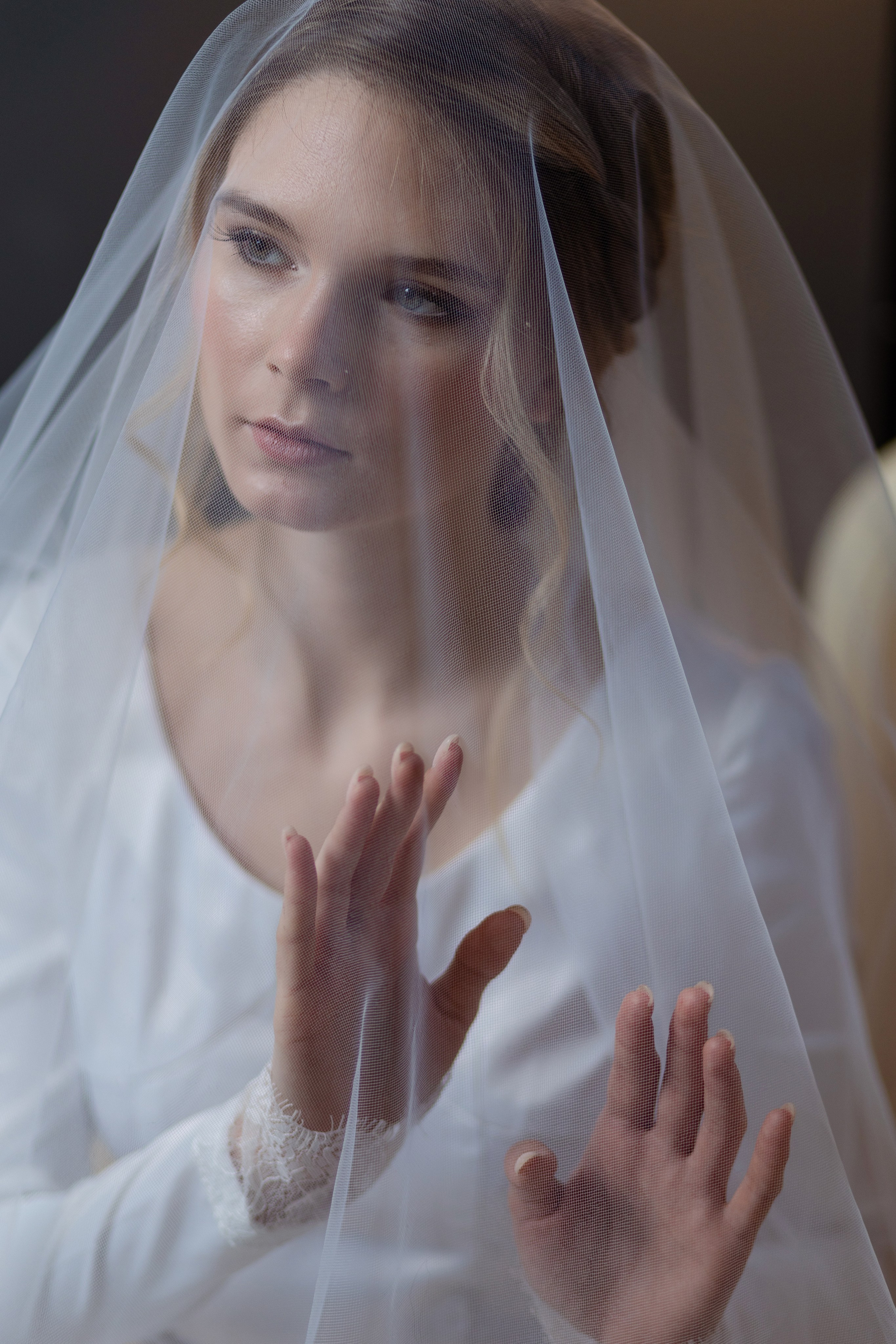 Невеста покрыта вуалью, на переднем плане руки невесты.