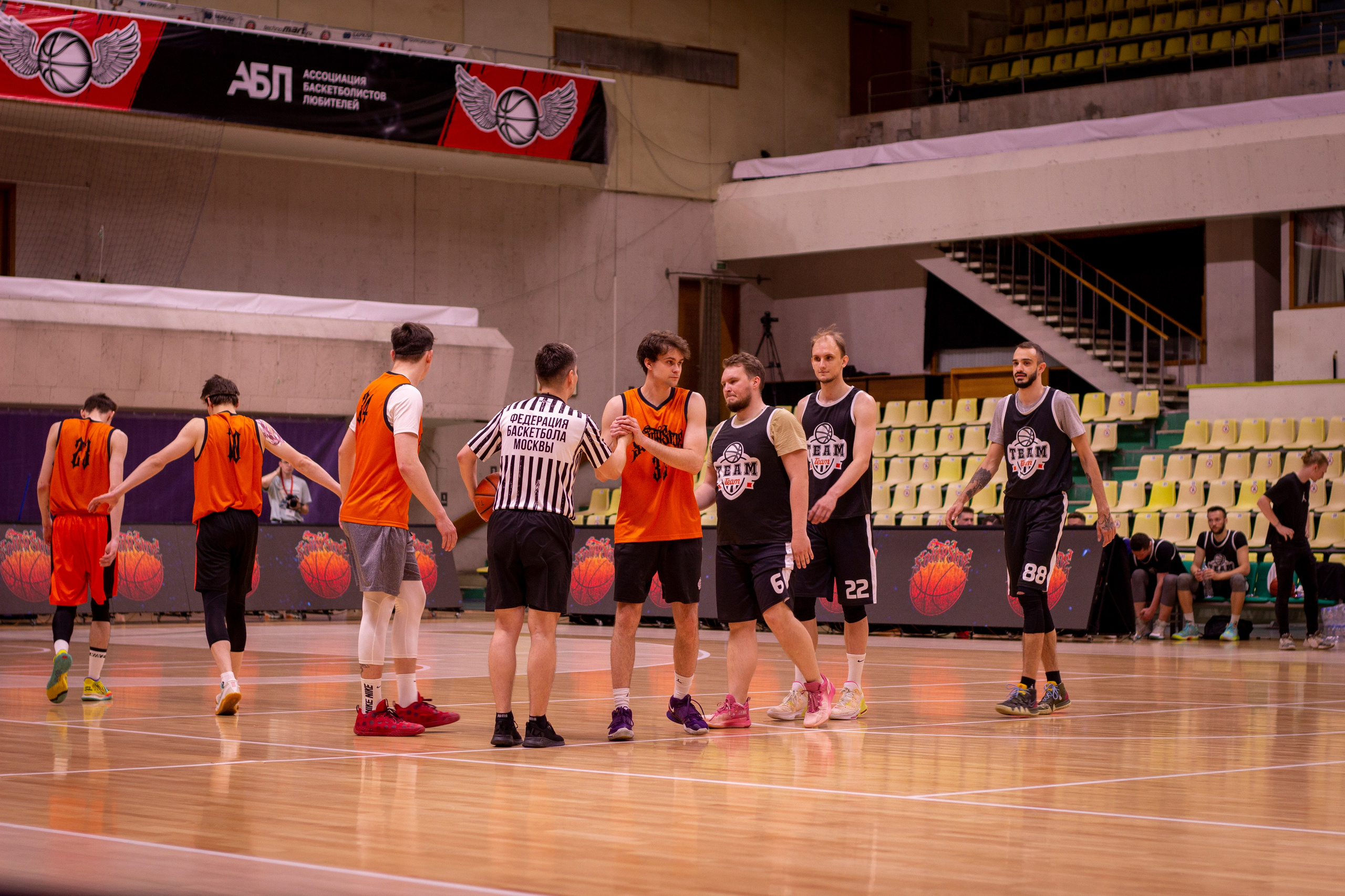 Спортсмены проводят баскетбольный матч на закрытой площадке