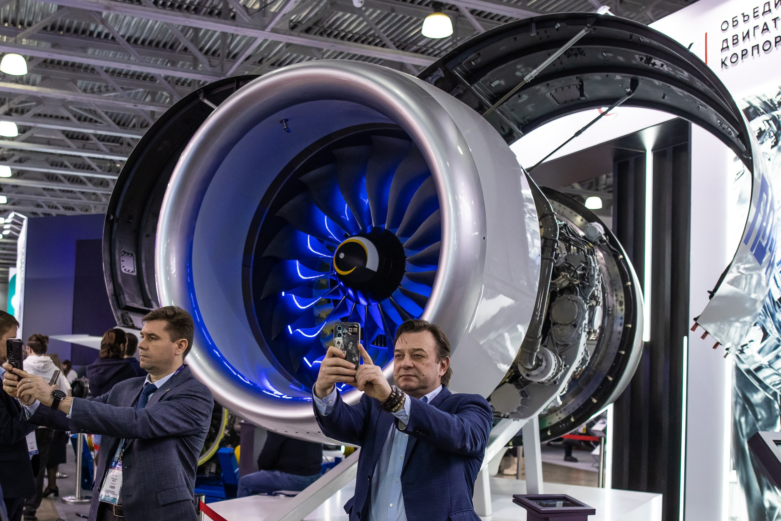 Мужчина делает селфи на фоне авиационного двигателя