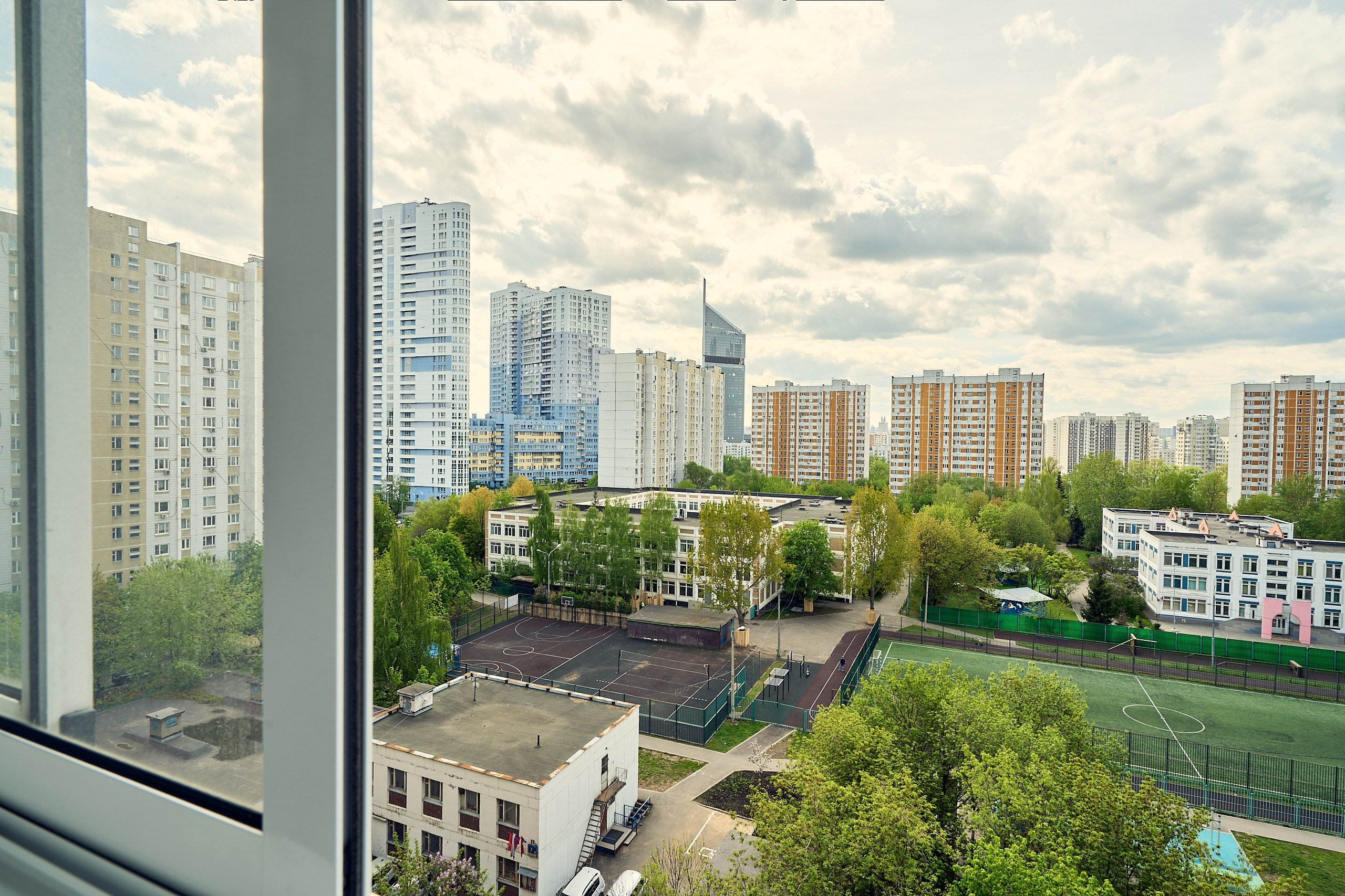 Фрагмент интерьерной фотосъемки с видом из окна на зеленый двор обычной московской панельки