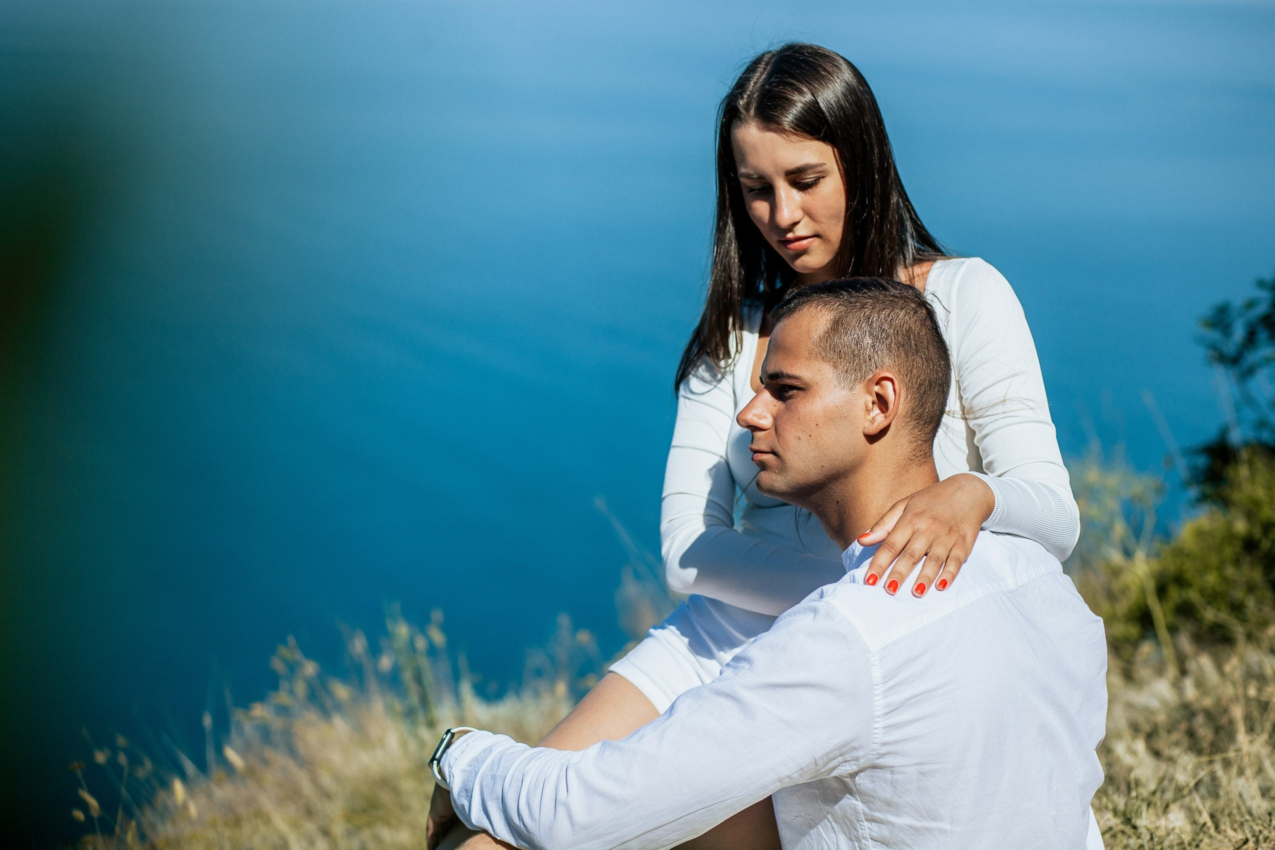 Влюбленные сидят на Лысой Горе с красивым видом на море и обнимаются.