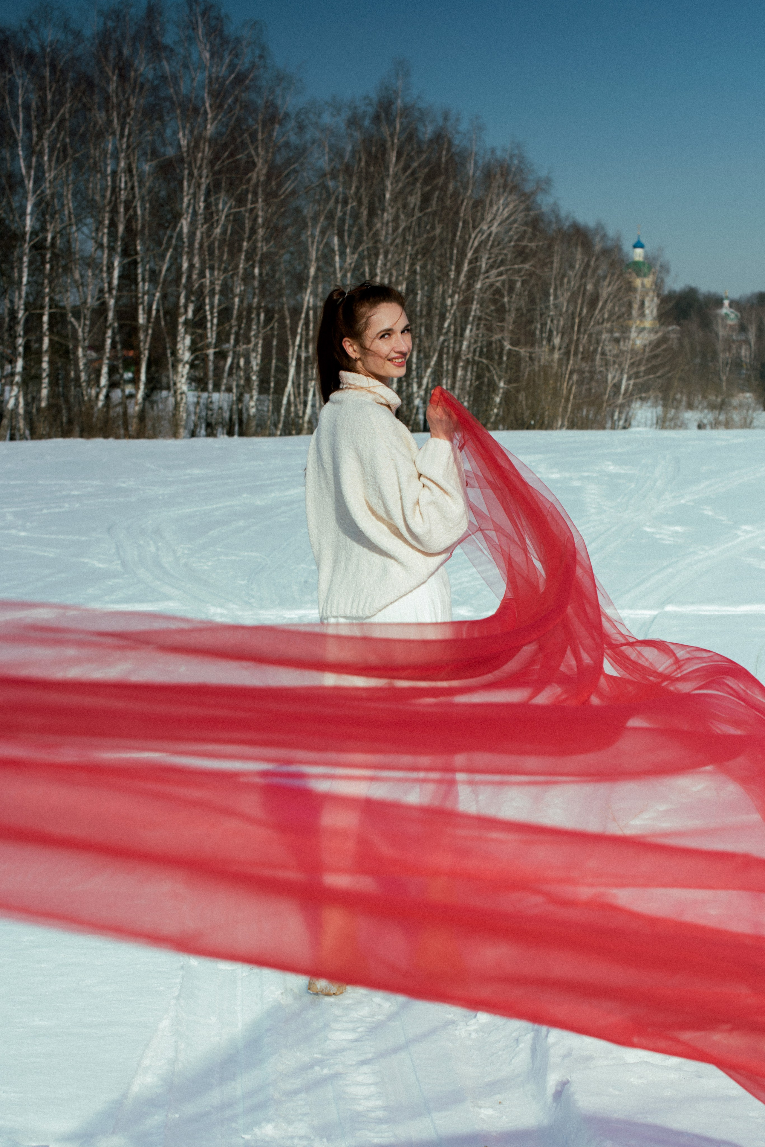 Фотосессия в зимней усадьбе Гребнево — белый свитер, алый фатин, снег.