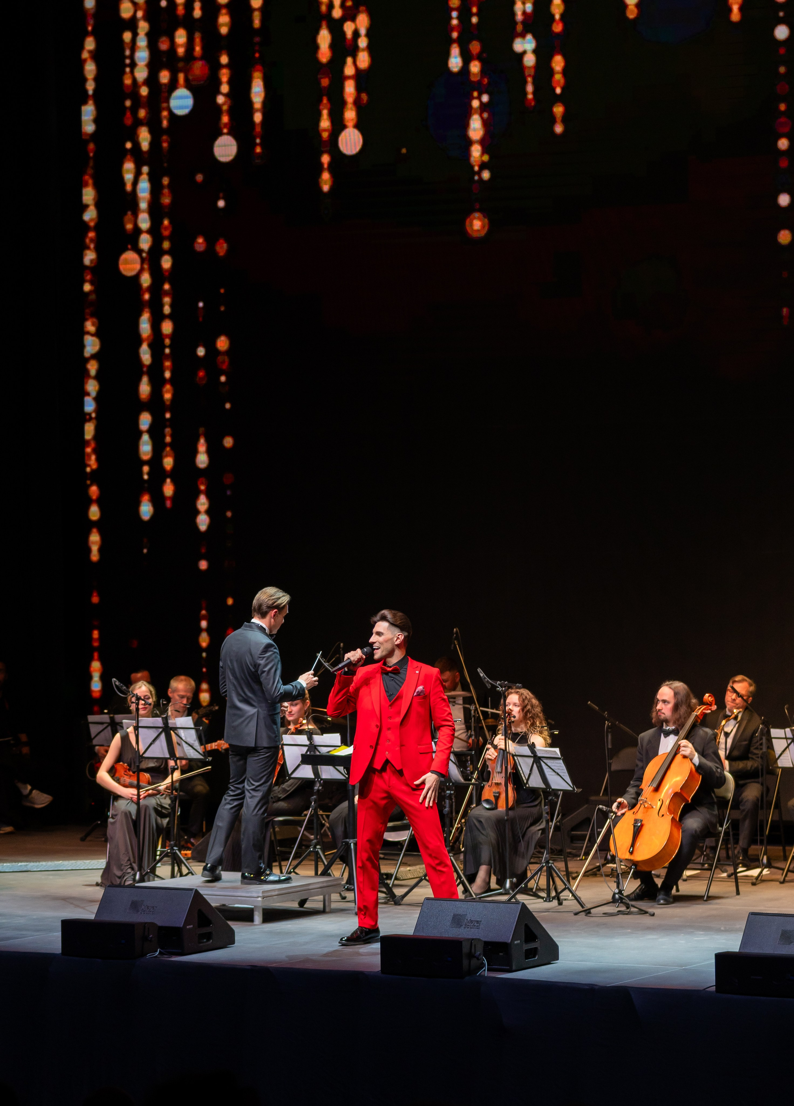 Яркое выступление солиста в красном костюме с симфоническим оркестром на праздновании Дня местного самоуправления | Фото: Евгений Мальцев.