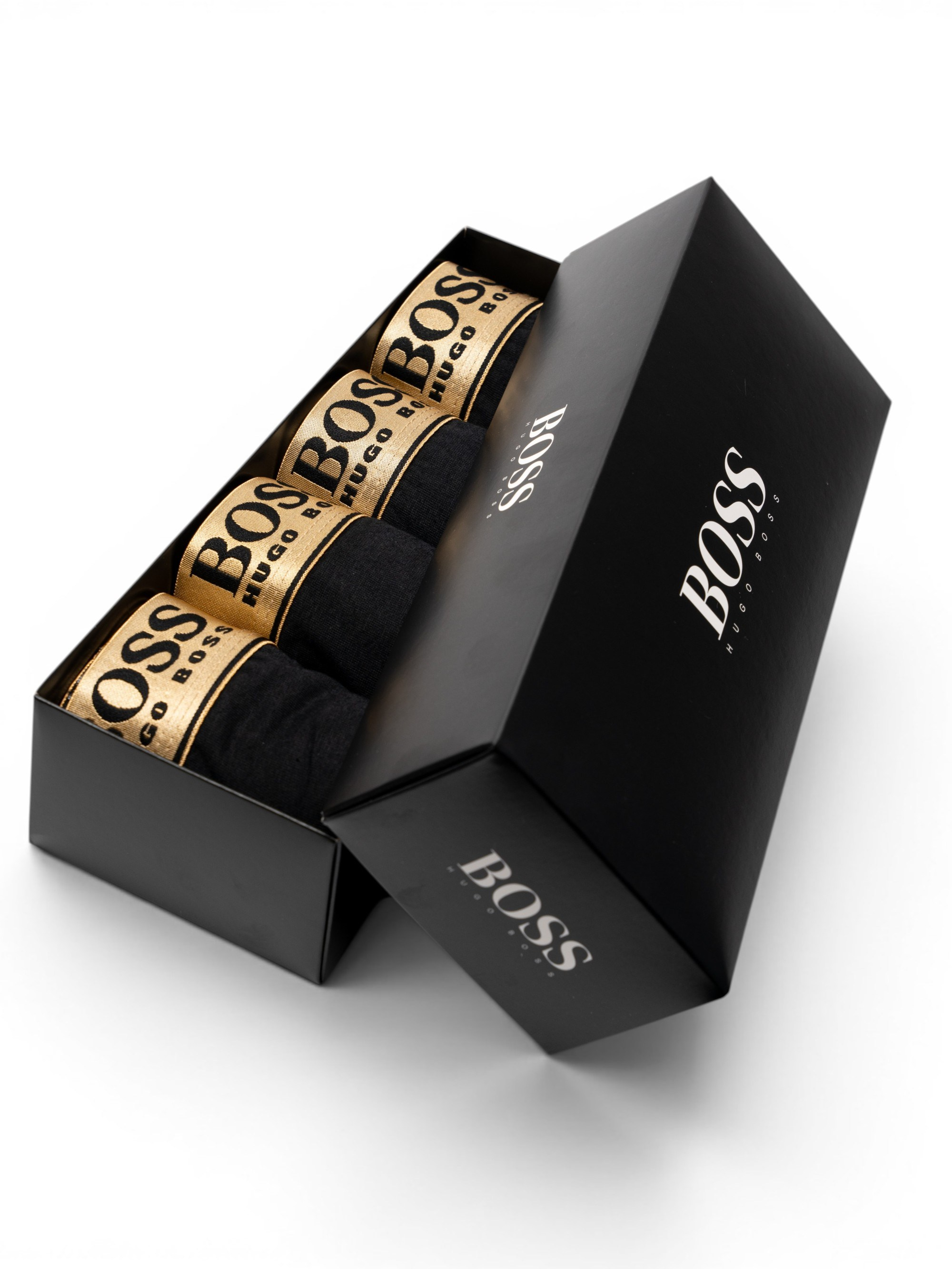 Набор чёрных боксёров Hugo Boss с золотистыми поясами в фирменной чёрной коробке на белом фоне.