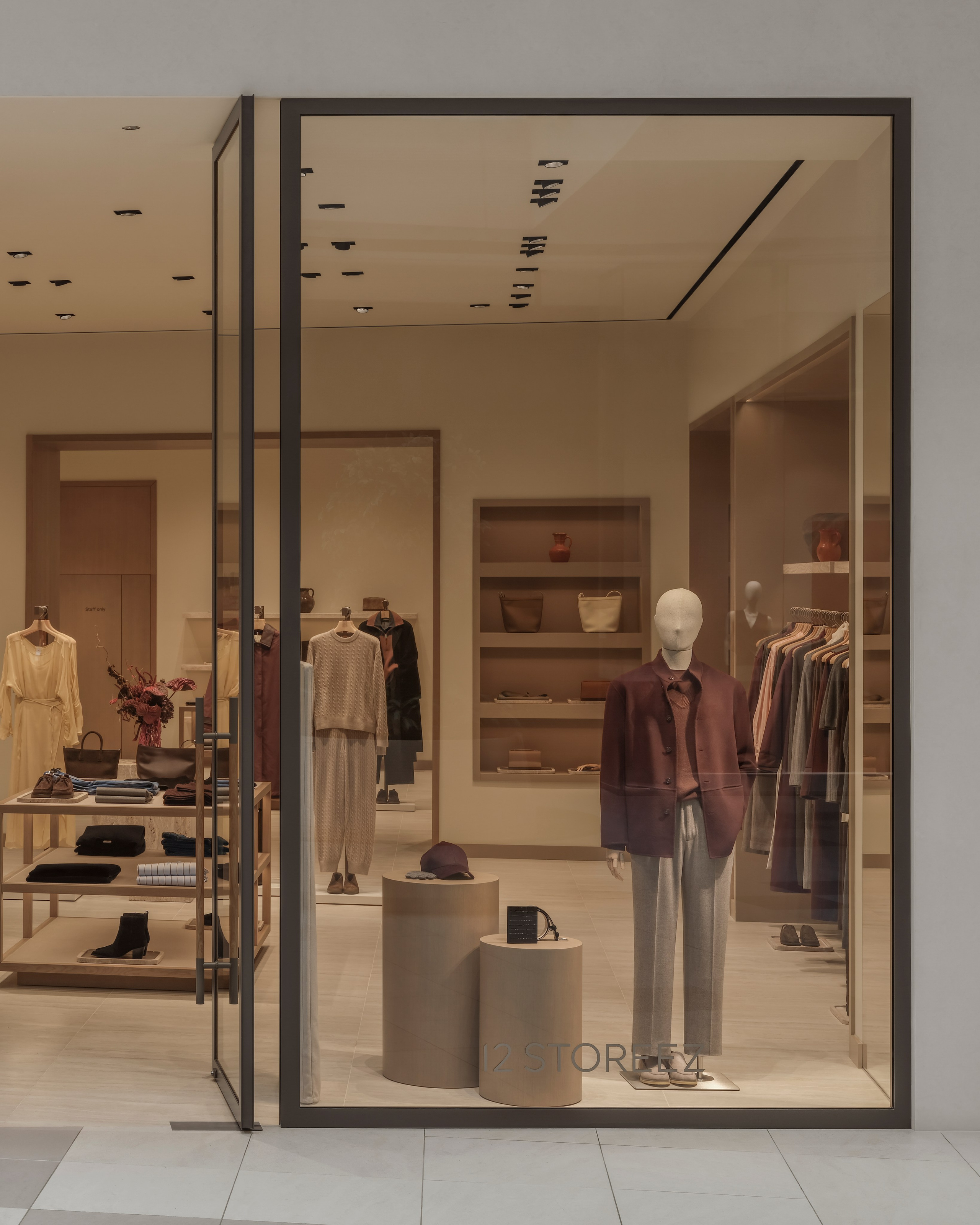 Boutique window display at the 12 STOREEZ store in Astana featuring premium fashion merchandising, clean architectural lines and warm interior lighting.