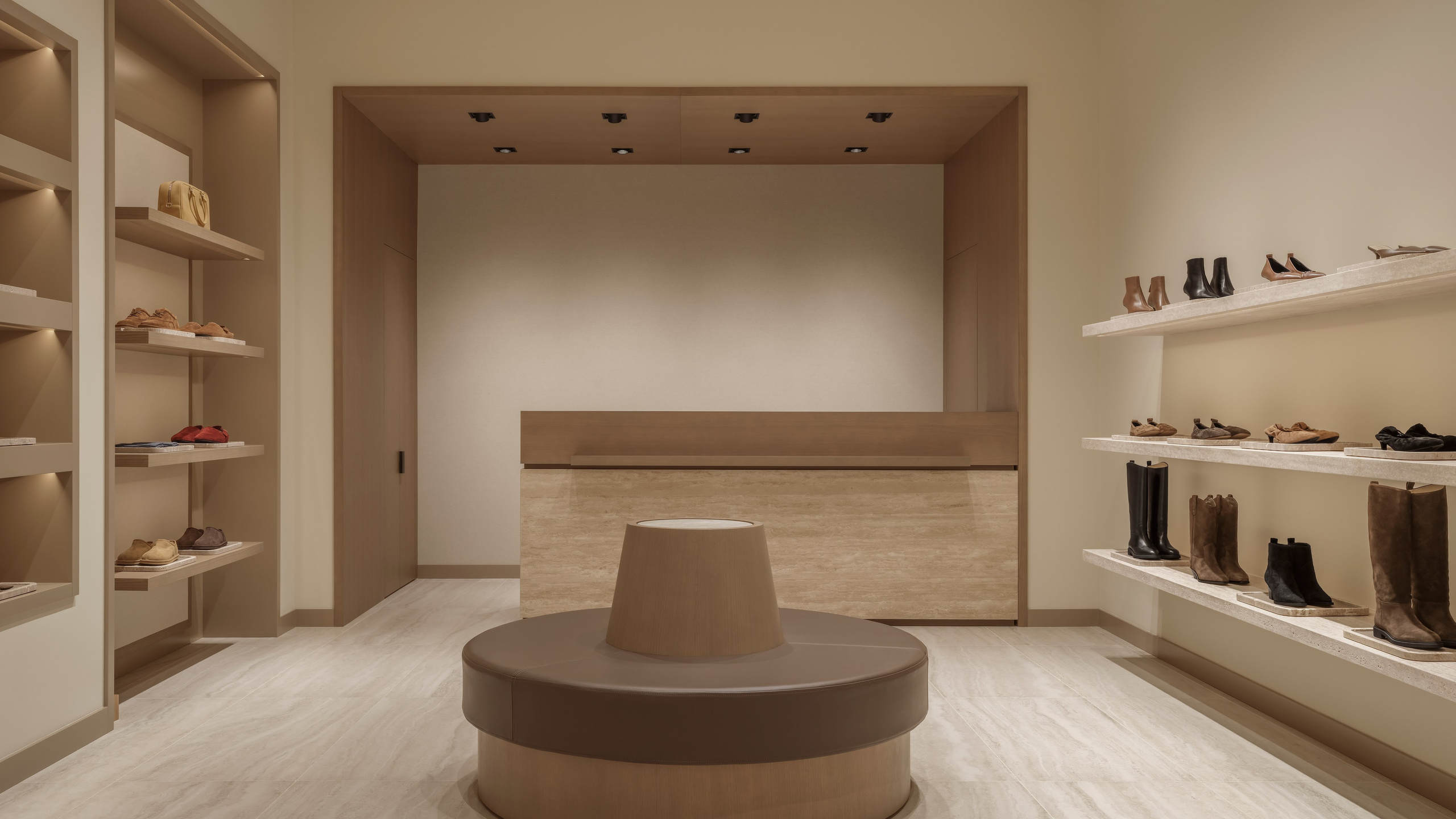Interior photography of the 12 STOREEZ boutique in Mega Silk Way, Astana, featuring a minimalist checkout area with natural stone, oak finishes and warm ambient lighting.