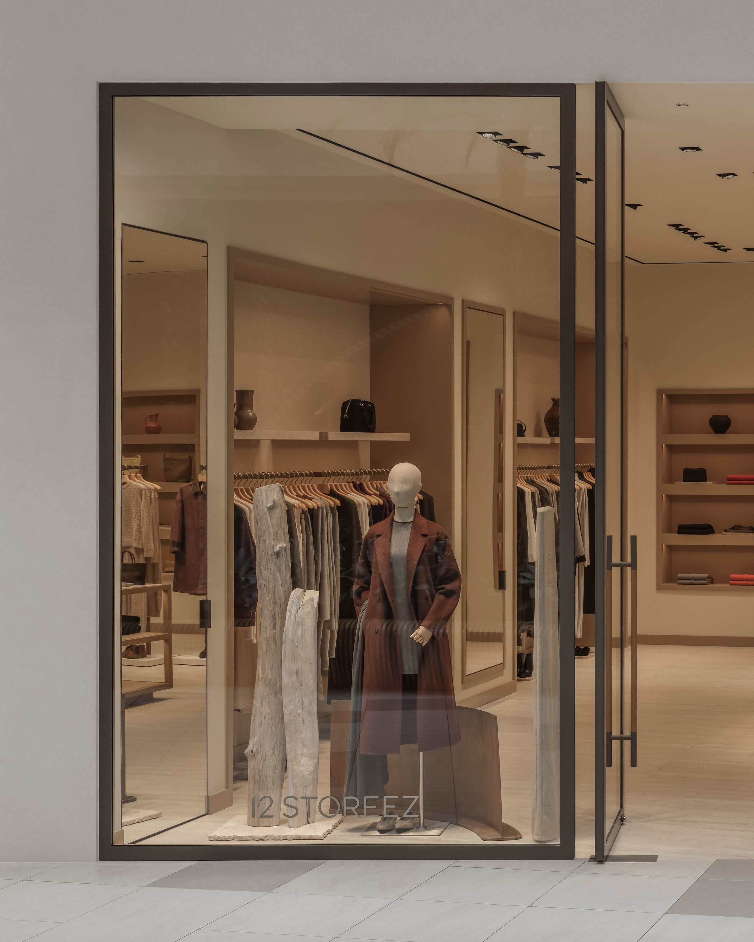 Exterior storefront window of the 12 STOREEZ boutique in Mega Silk Way, Astana, showcasing contemporary fashion retail design and minimalist architecture.