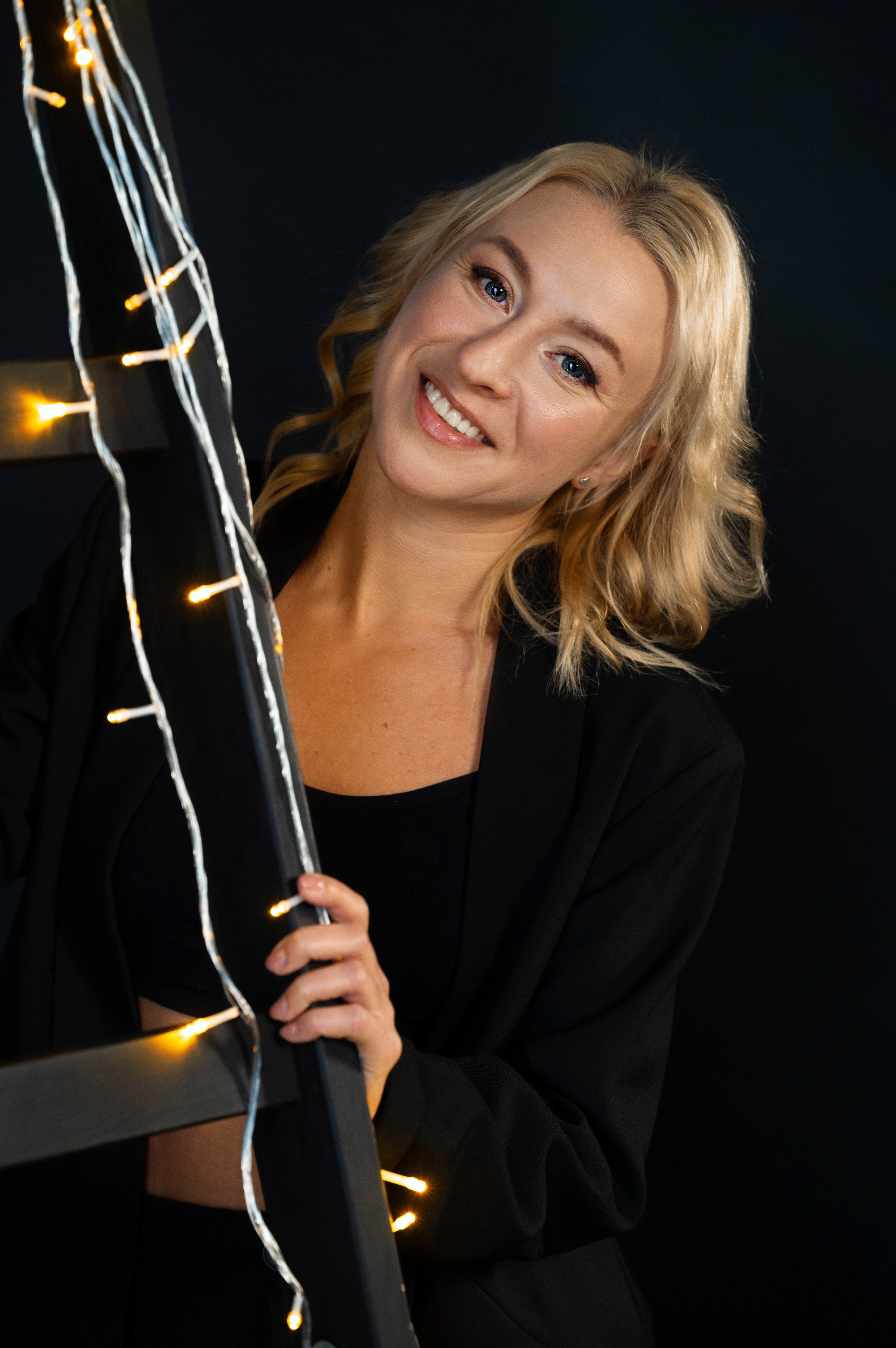 Новогодняя фотосъёмка девушки в черном костюме