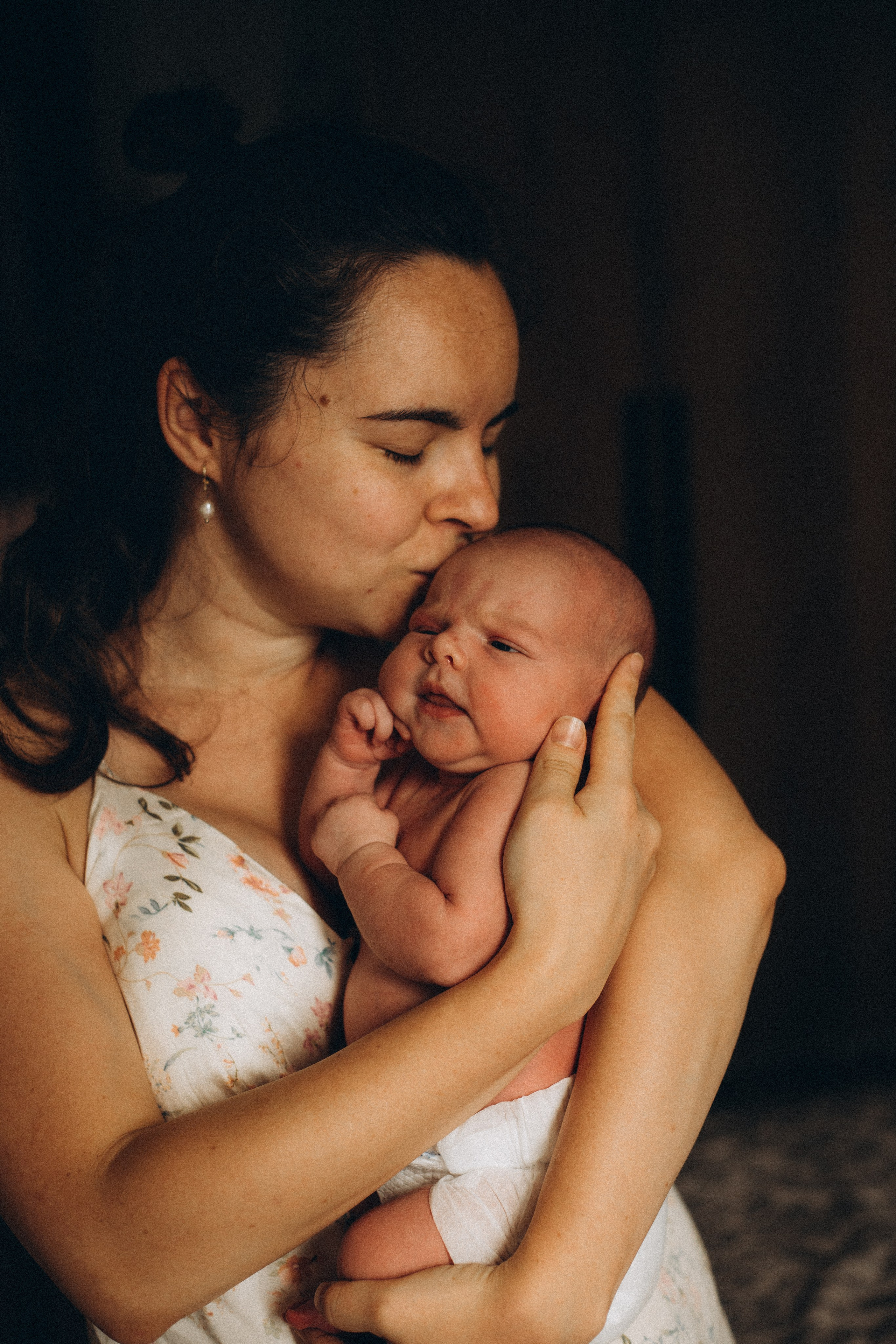 фотография, где мама обнимает и целует новорожденного ребенка