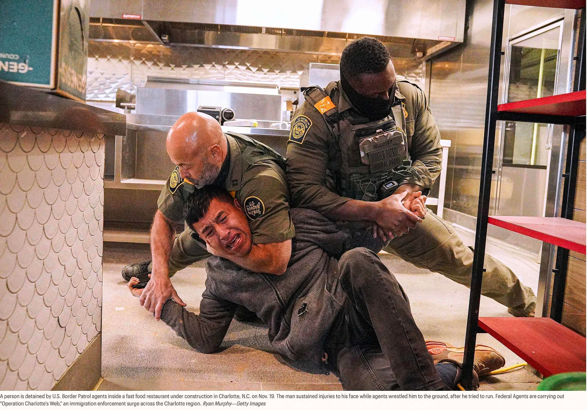 19 ноября агенты пограничной службы США задержали человека в строящемся ресторане быстрого питания в Шарлотте, Северная Каролина. Мужчина получил травмы лица, когда агенты повалили его на землю после того, как он попытался сбежать. Федеральные агенты проводят операцию «Паутина Шарлотты» — масштабную операцию по обеспечению соблюдения иммиграционного законодательства в регионе Шарлотт.Райан Мерфи — Getty Images