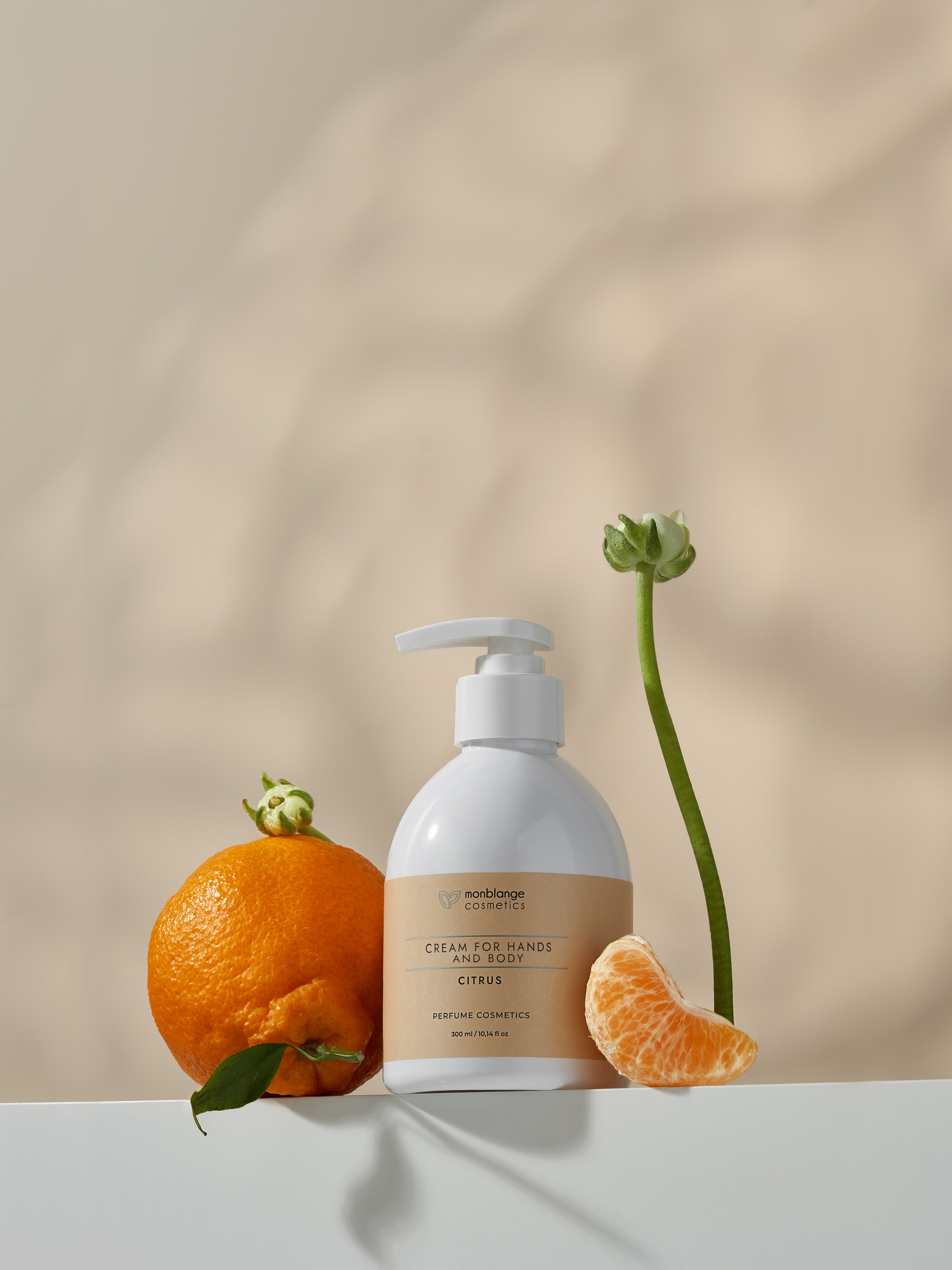 Крем для тела стоит на белом подиуме рядом с мандарином