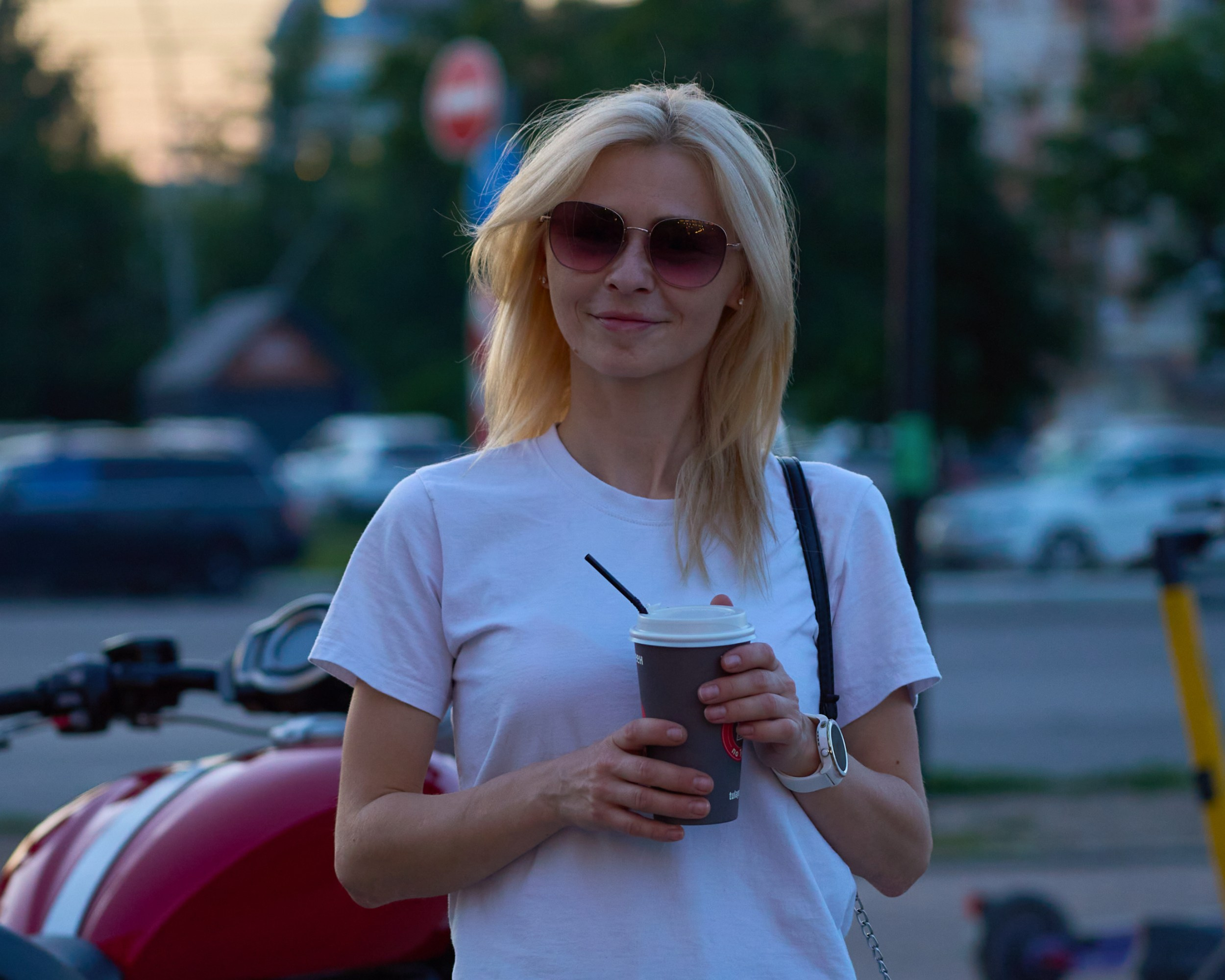 Портрет блондинки в белой футболке с кофе навынос на фоне улицы Тулы и красного мотоцикла — фотограф Кураков Максим, Тула