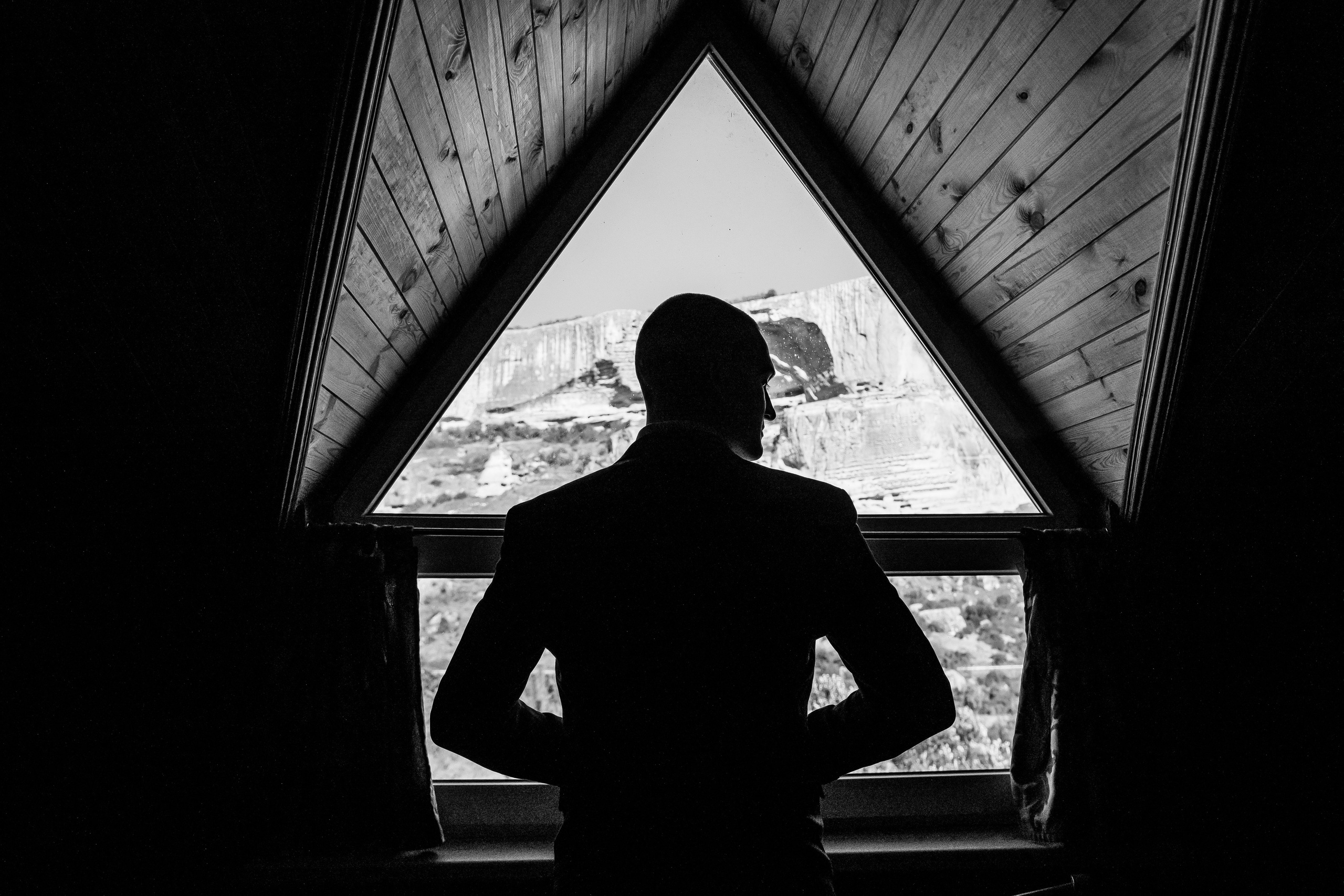 парень напротив окна надевает пиджак 