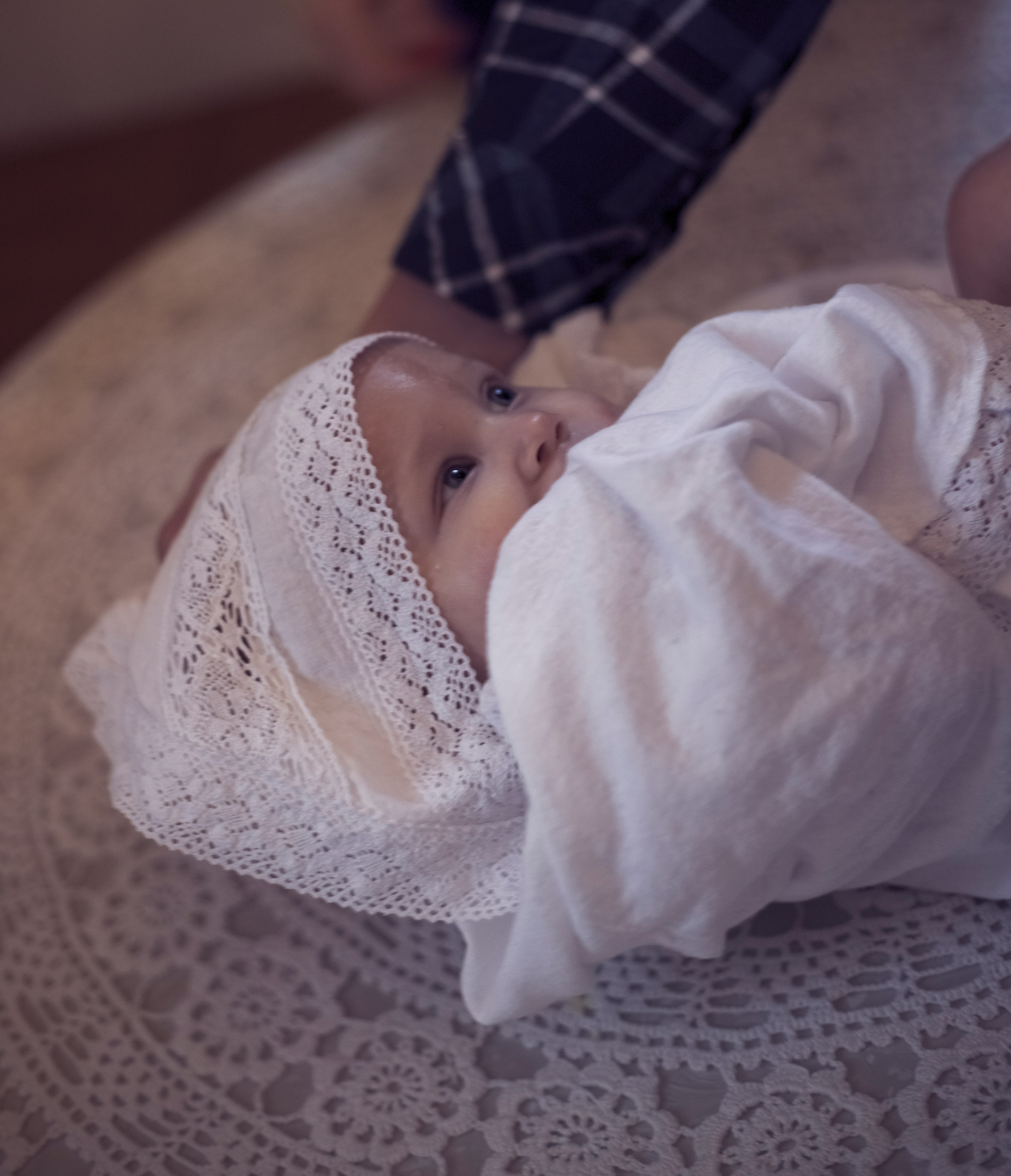 ребенок после купания в чане одет в крестильную рубашку