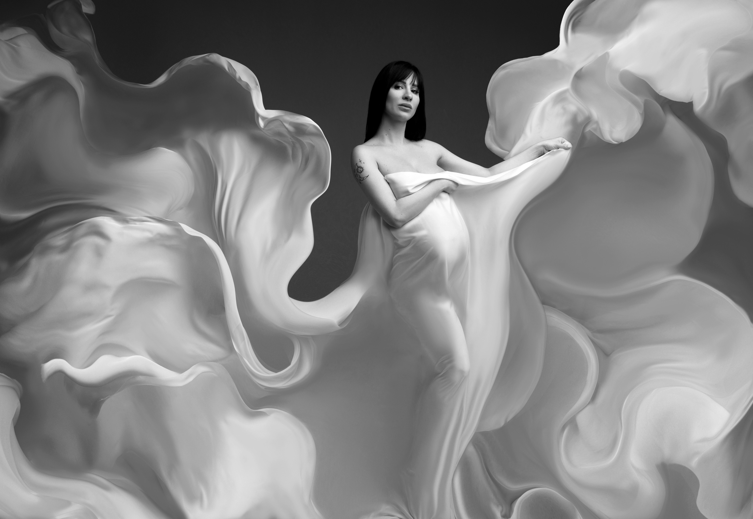 Фотосессия беременной девушки в летящем белом шелке.