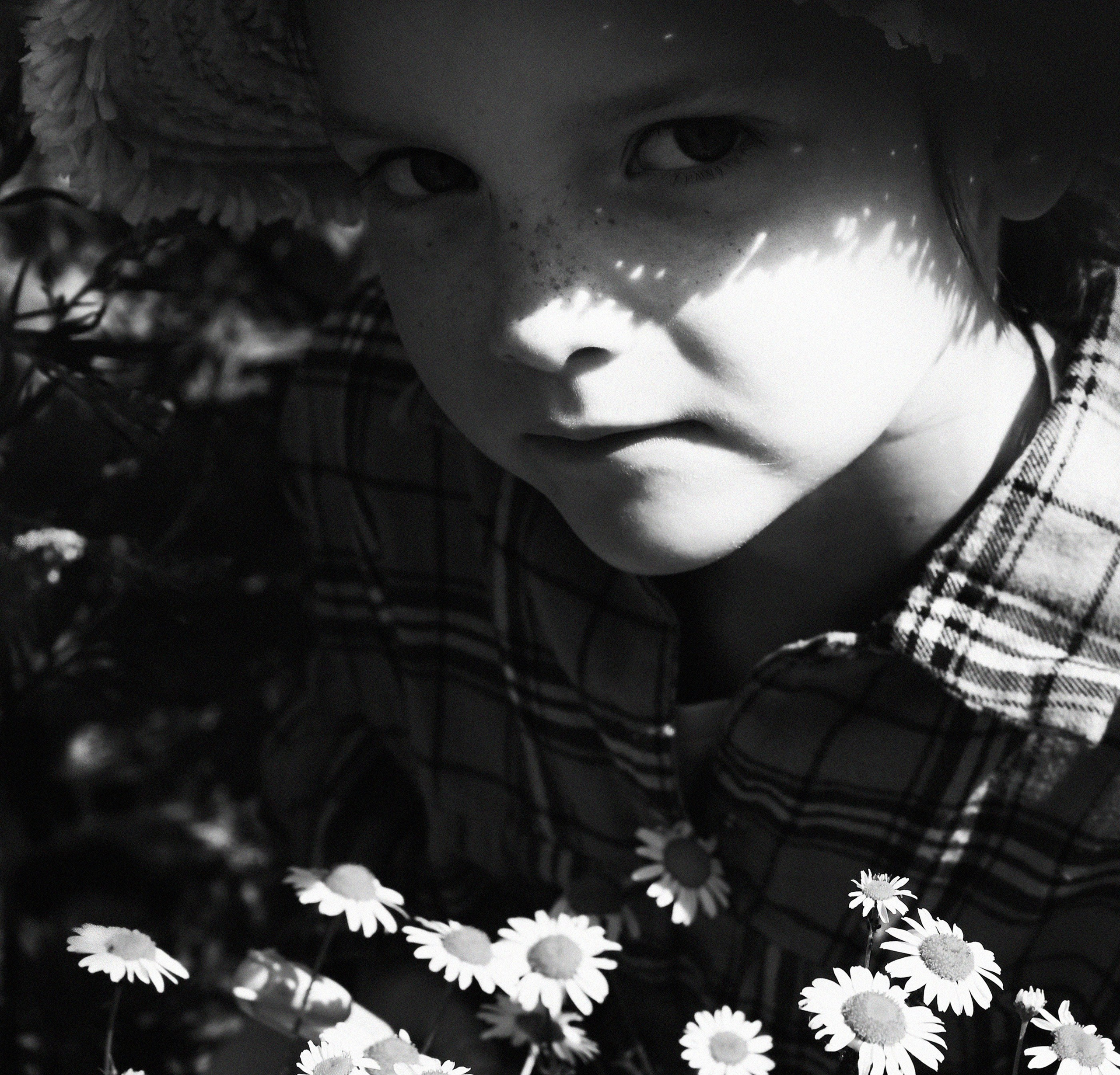Черно-белый портрет ребенка на солнечной весенней поляне