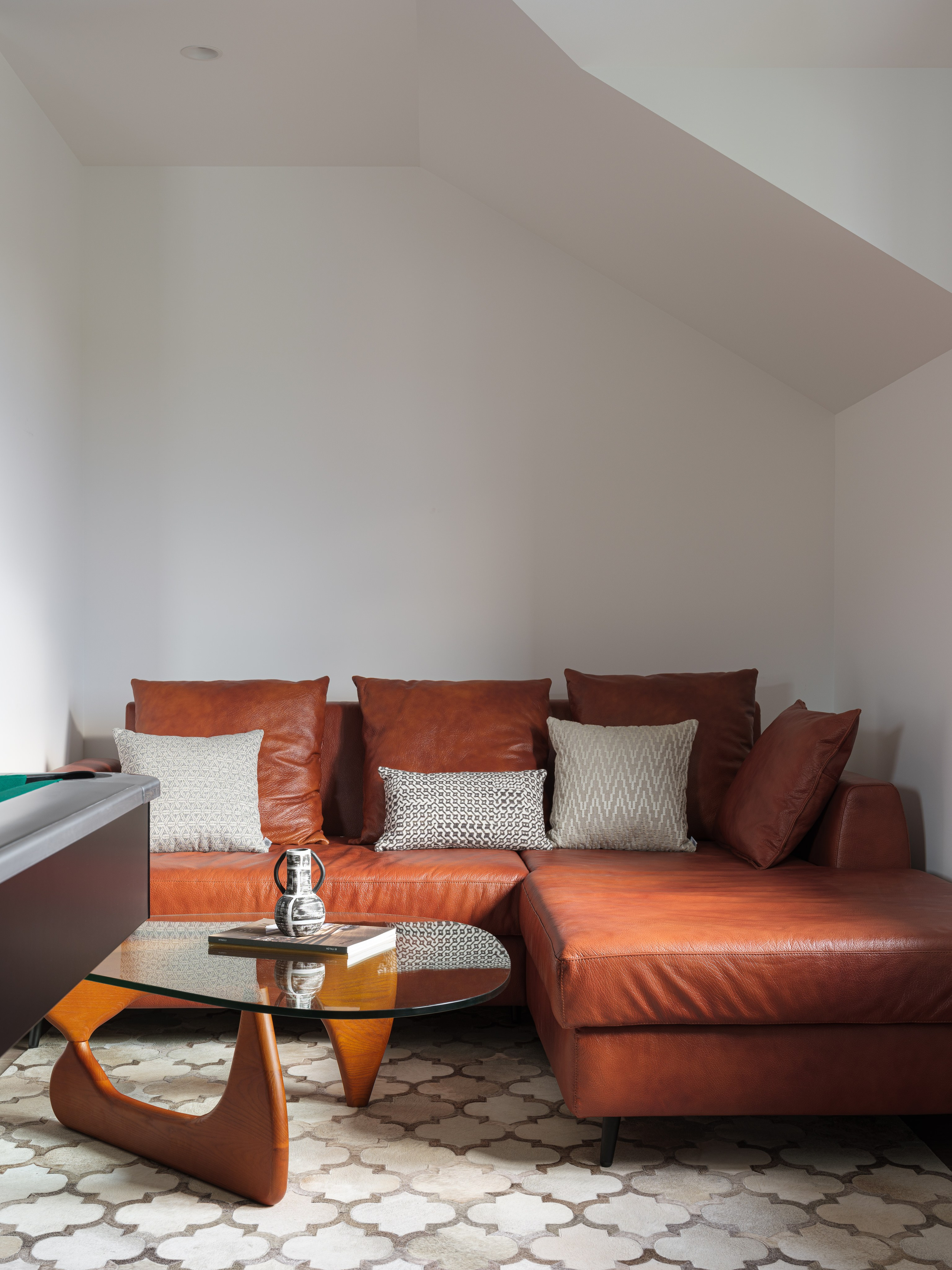 Современный интерьер комнаты отдыха с коричневым кожаным диваном и дизайнерским стеклянным столиком, создающим уют и стиль. Проект от дизайнера Татьяны Диденко, фото Сергея Денисенко, стилизация Натальи Якушевой.